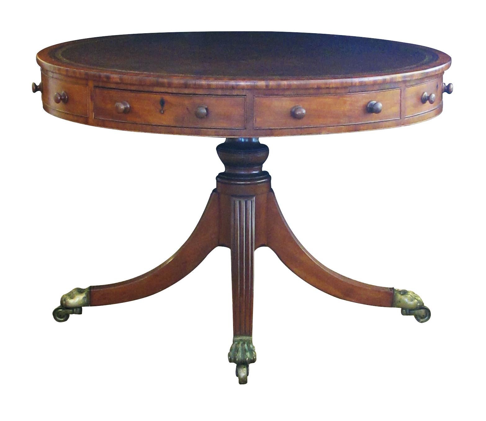 A fine example of an English rent table with circular inset-leather top above an apron fitted with four numbered drawers and four blind drawers all with original pulls; over a bulbous pedestal raised on splayed reeded legs with original hairy-paw