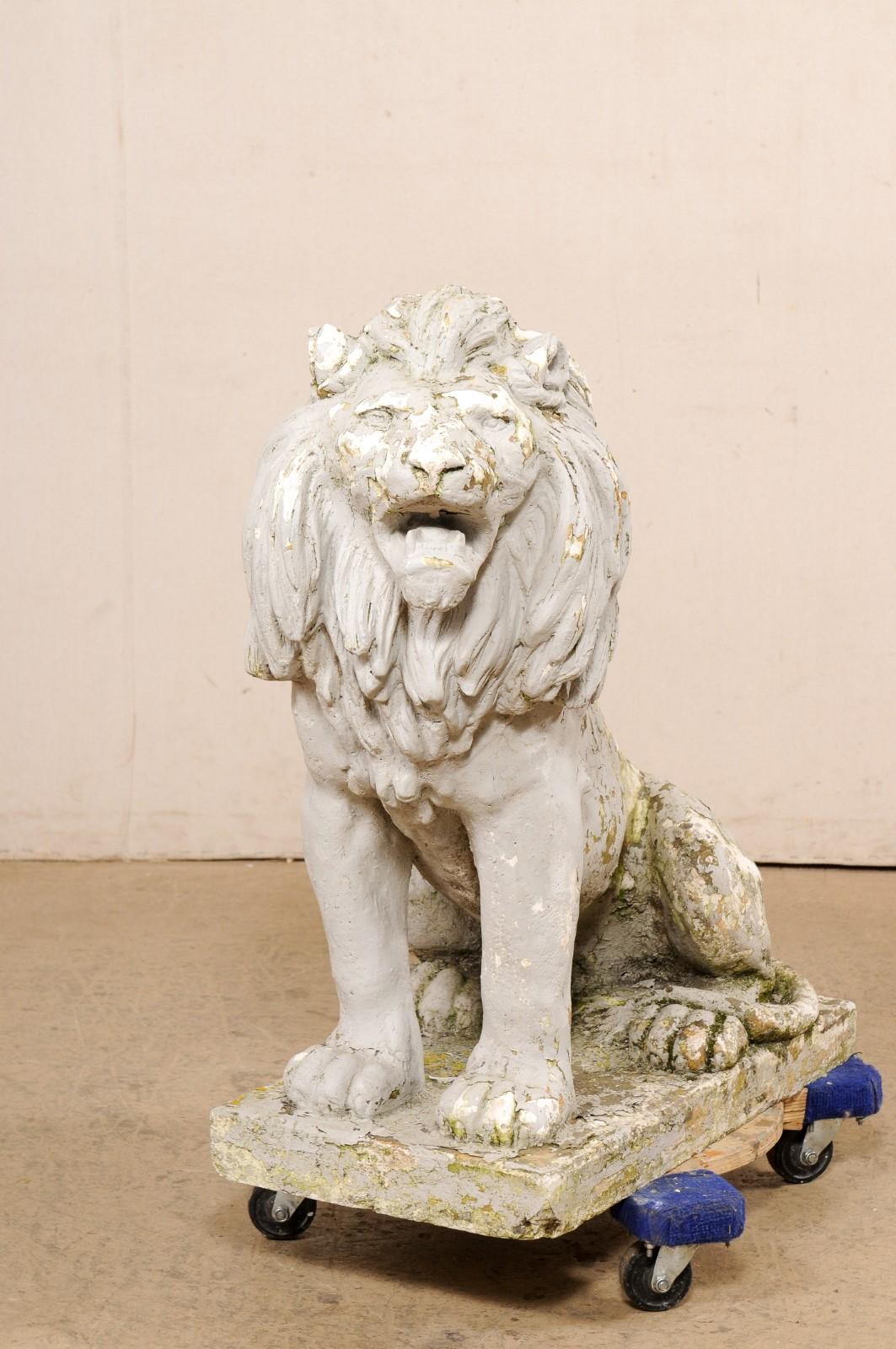 A regal French lion garden statue. This vintage cast-stone lion statue from France is abundant with fabulous details, such as the nicely textured mane, alert eyes, and open mouth. He is positioned in a seating position with tail wrapping around his