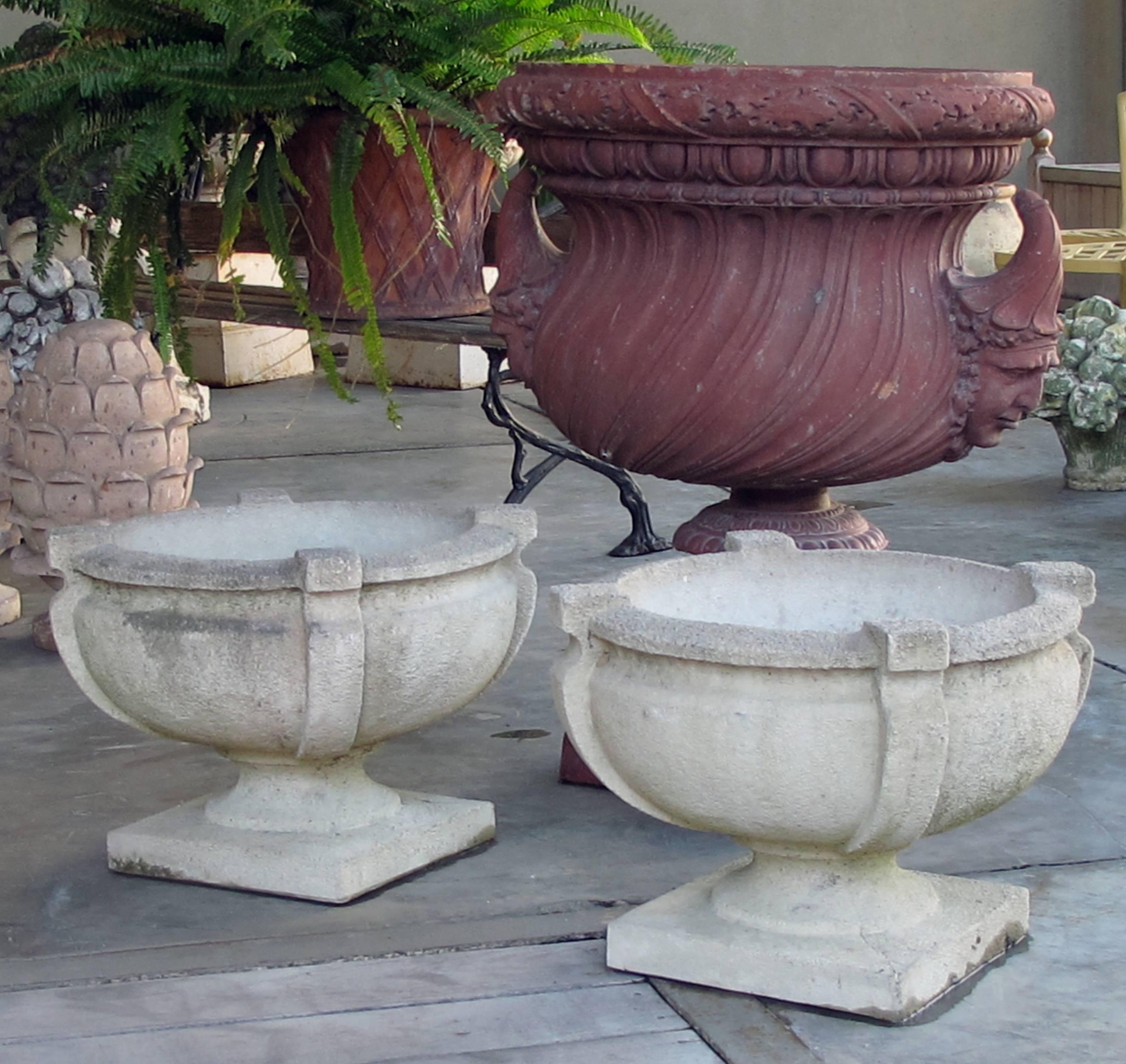 Each robust cup-shaped urn with rolled lip resting on a square base; stamped.