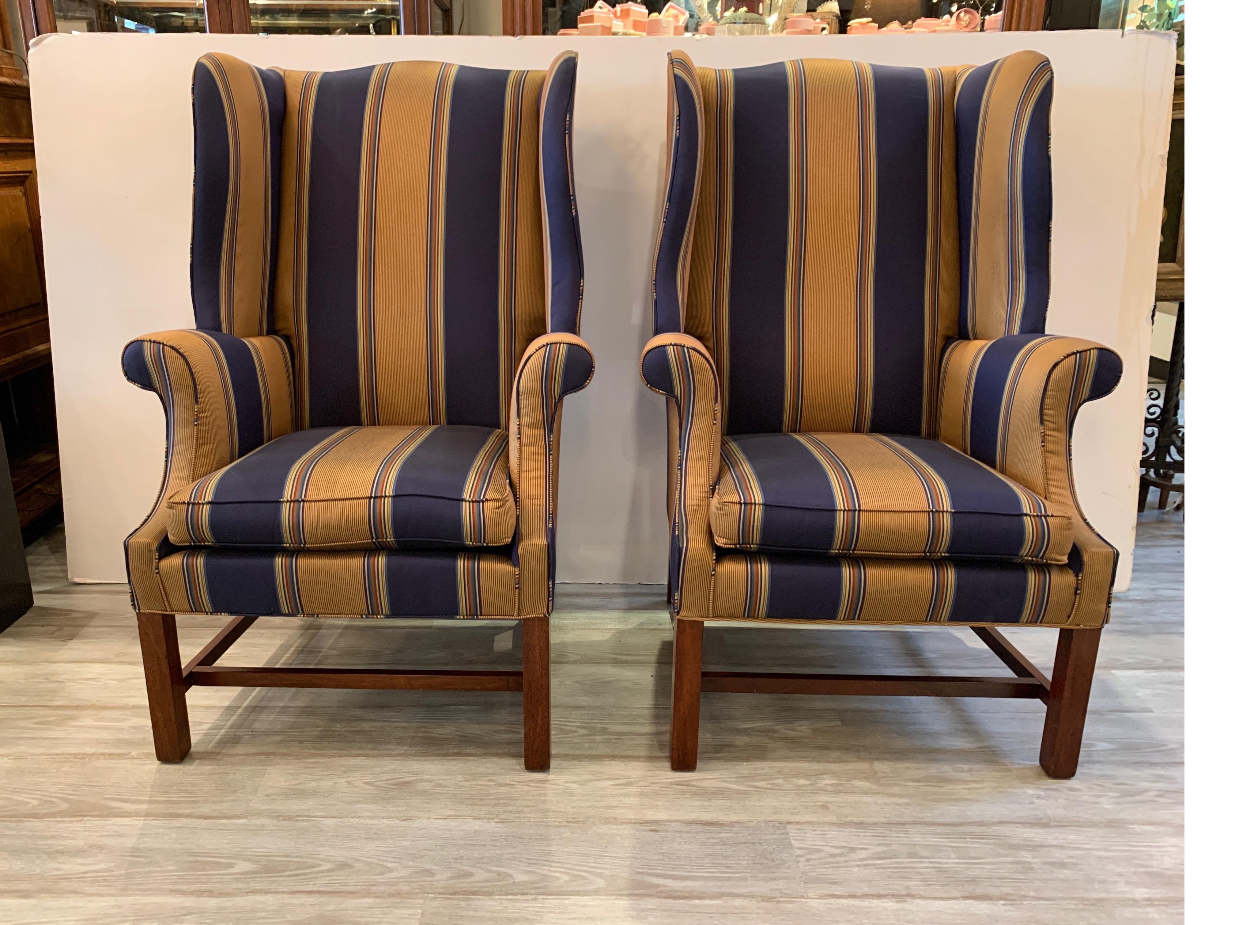 A nice pair of custom decorator navy and gold stripped wing chairs with mahogany Chinese Chippendale legs. The chairs are a nice size at 30 wide, and 30 deep, with a high back of 45 inches tall. These are custom chairs from a decorator manufacturer.