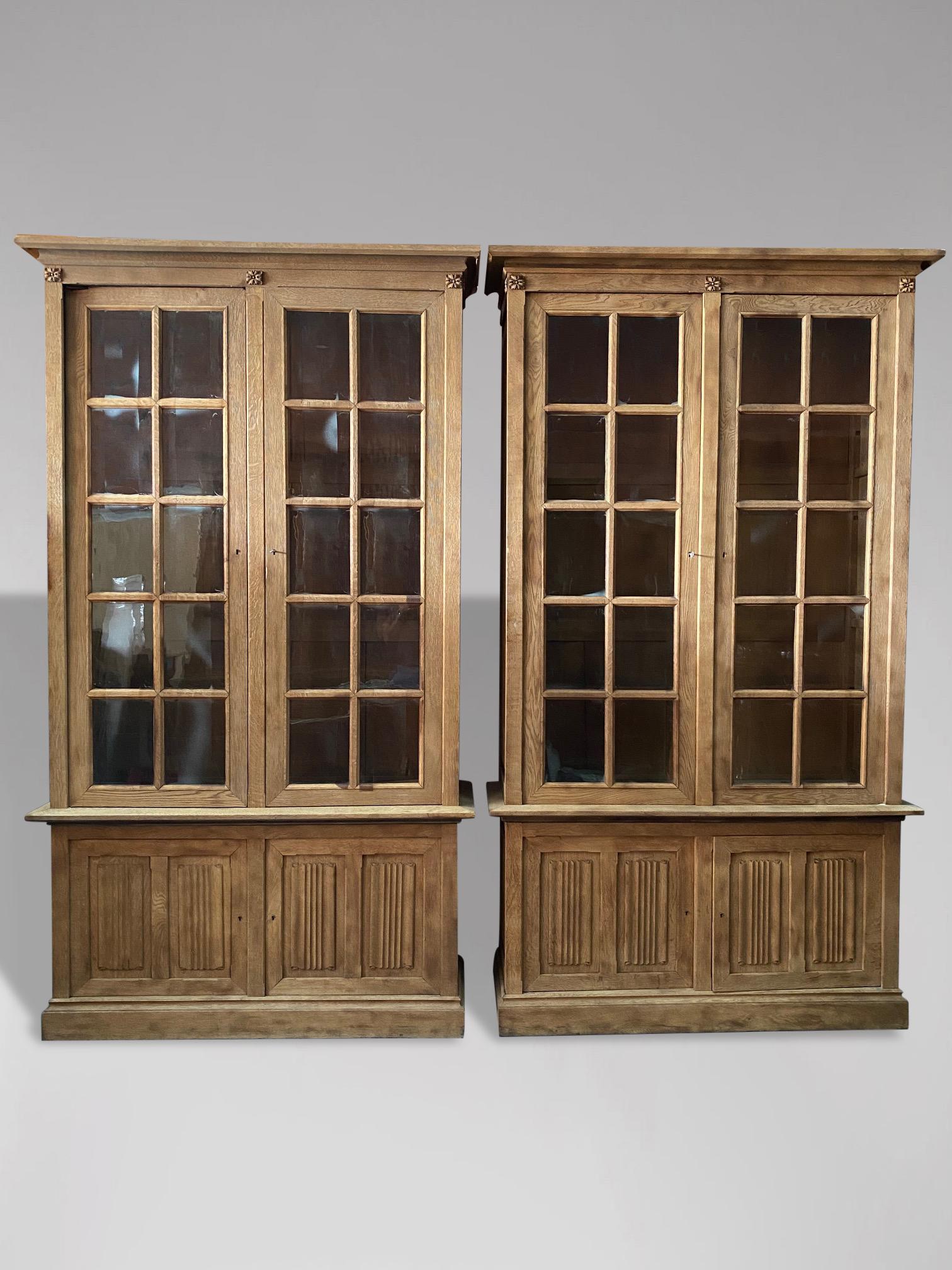A handsome pair of 19th century oak astragal glazed bookcase cabinets on linenfold carved cupboards dating to circa 1880. The moulded cornice above a pair of rectangular glass pane doors and on a cupboard base with a pair of oak linenfold carved