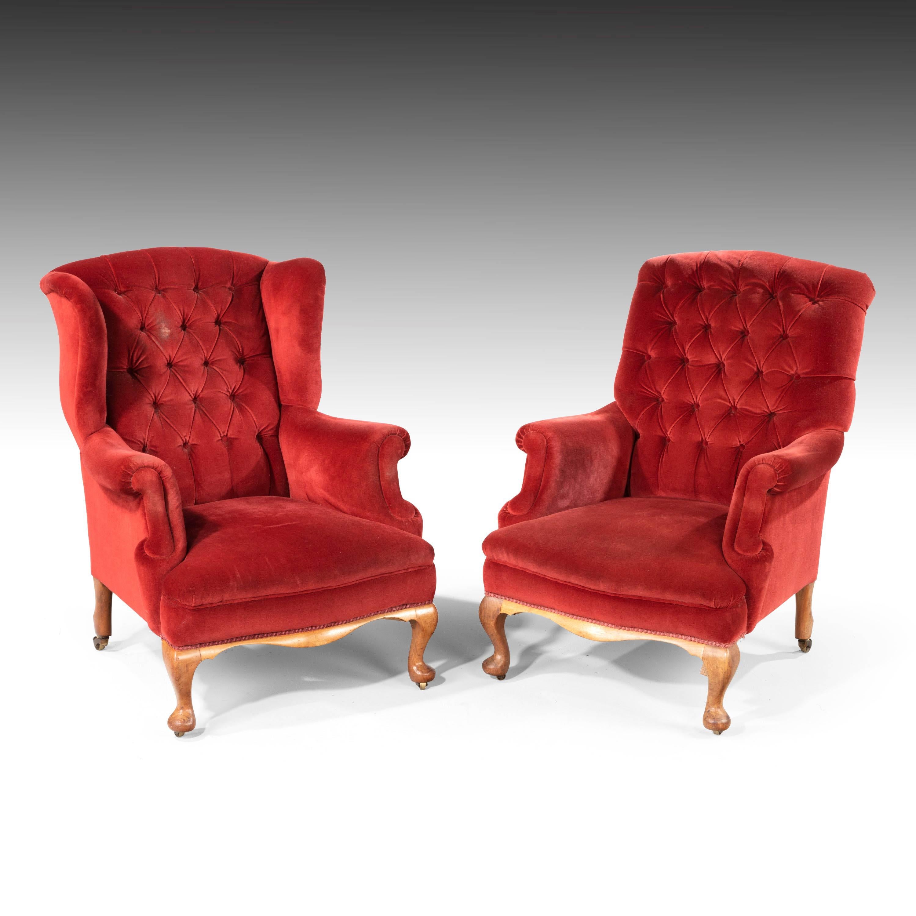 A handsome pair of shapely easy chairs. With serpentine wings and scrolled arms. Of substantial size. The supports of Queen Anne design with a scrolled foot with a wavy front border. With horse hair interiors. Now slightly tired but still in