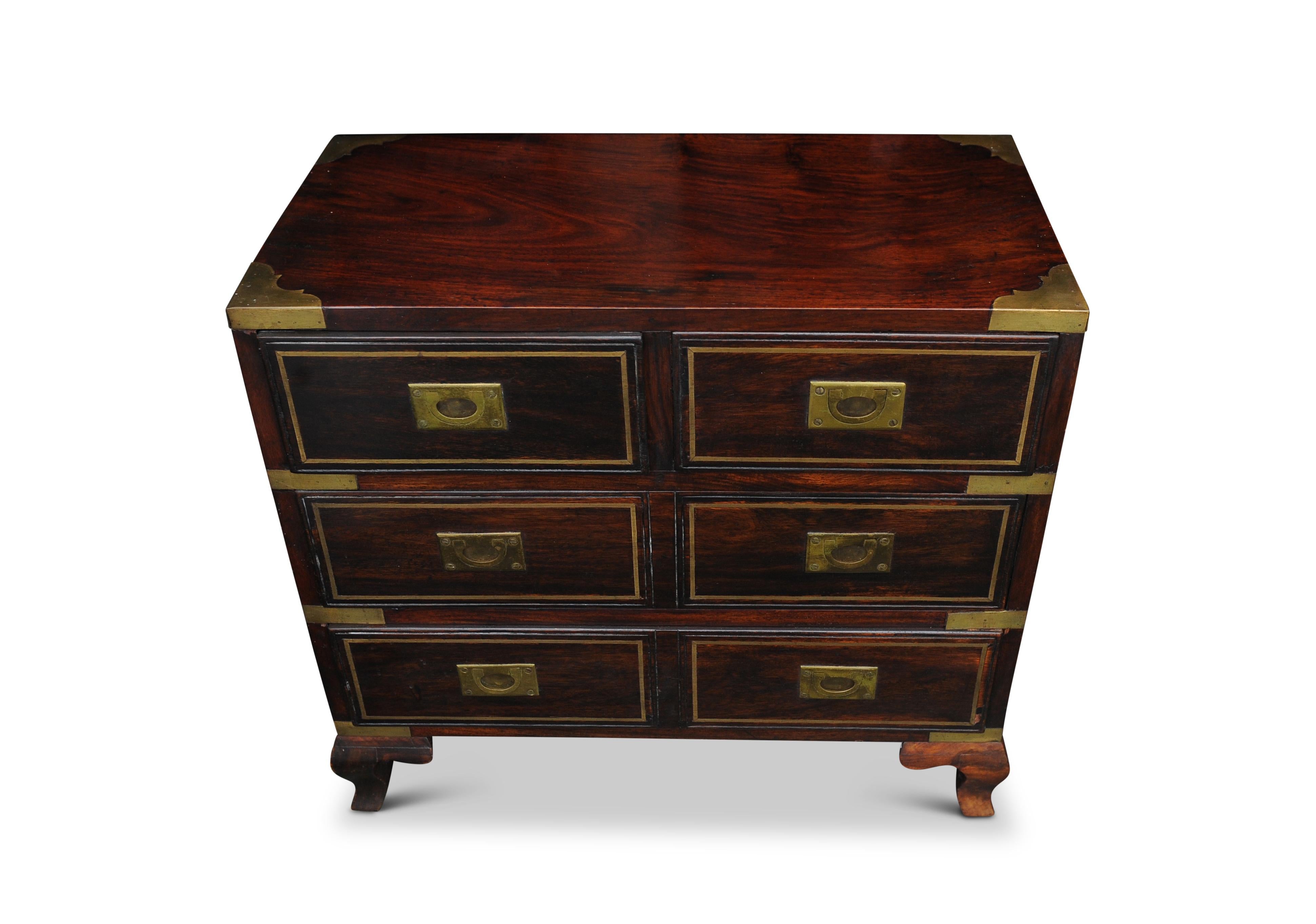 Early 20th century hardwood campaign brass bound chest of two short and two long drawers with sunken brass handles, raised upon out swept feet.



