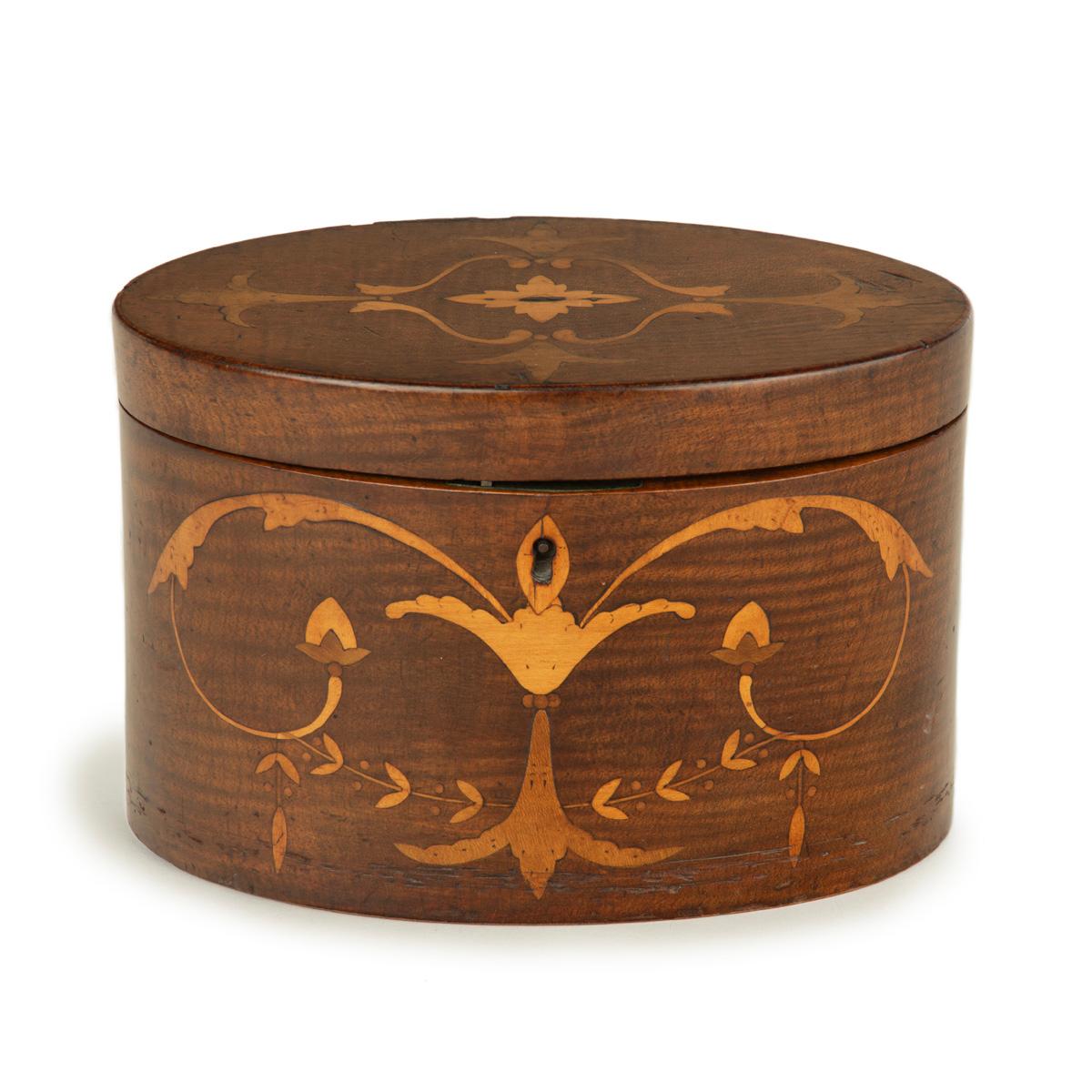A harewood marquetry tea caddy with Royal Provenance, of oval form with a hinged lid opening to reveal two zinc lined compartments, decorated in fruitwood and boxwood marquetry with classical motifs including winged palmettes and foliate scrolls, a