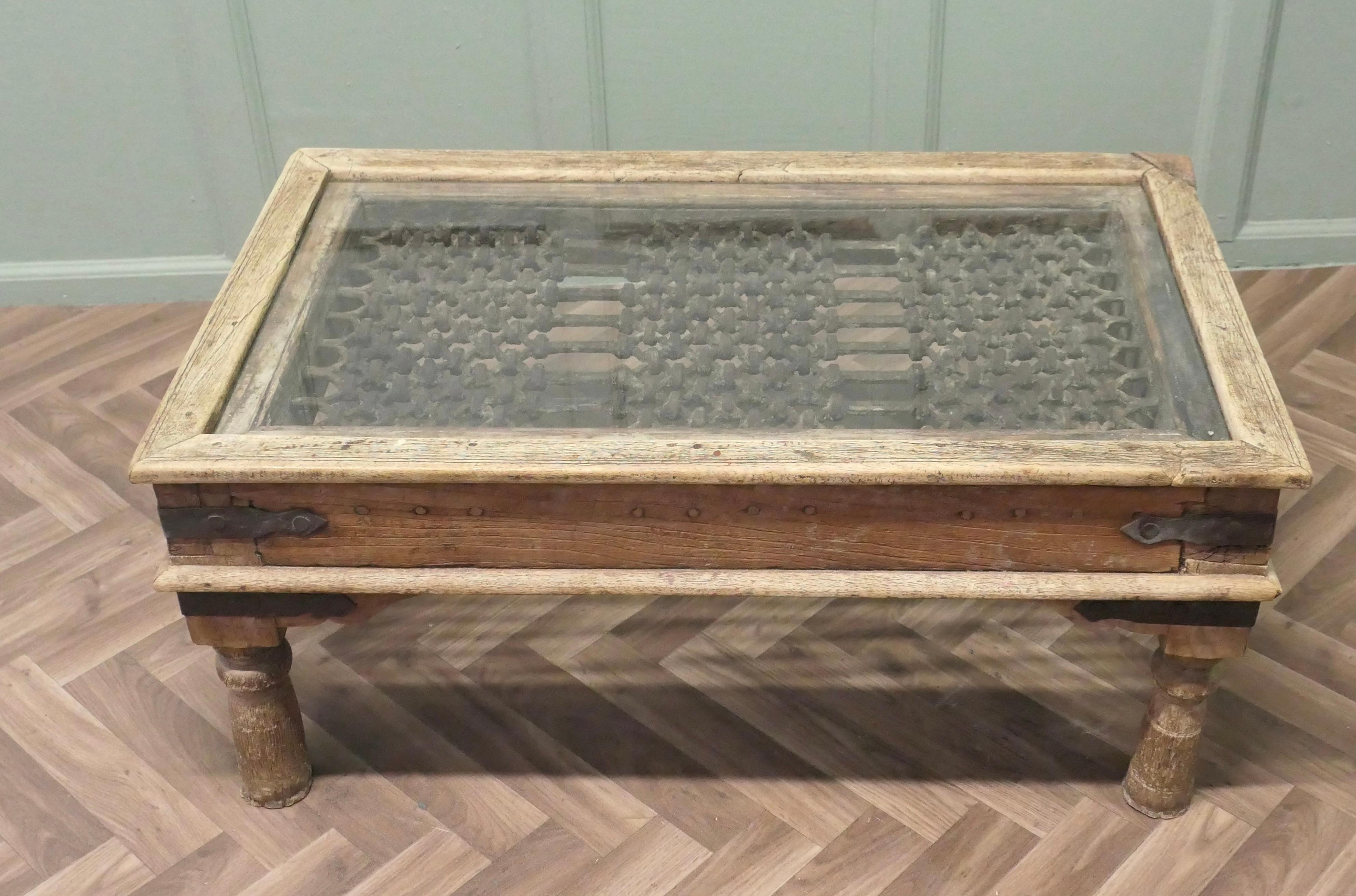 A Heavy Coffee Table with Inset Iron Grill Panel 

This table is made from a 19th century North African Door. It has a solid wood frame and has the decorative Wrought Iron security panel which is  set under glass for the design
The table is good and