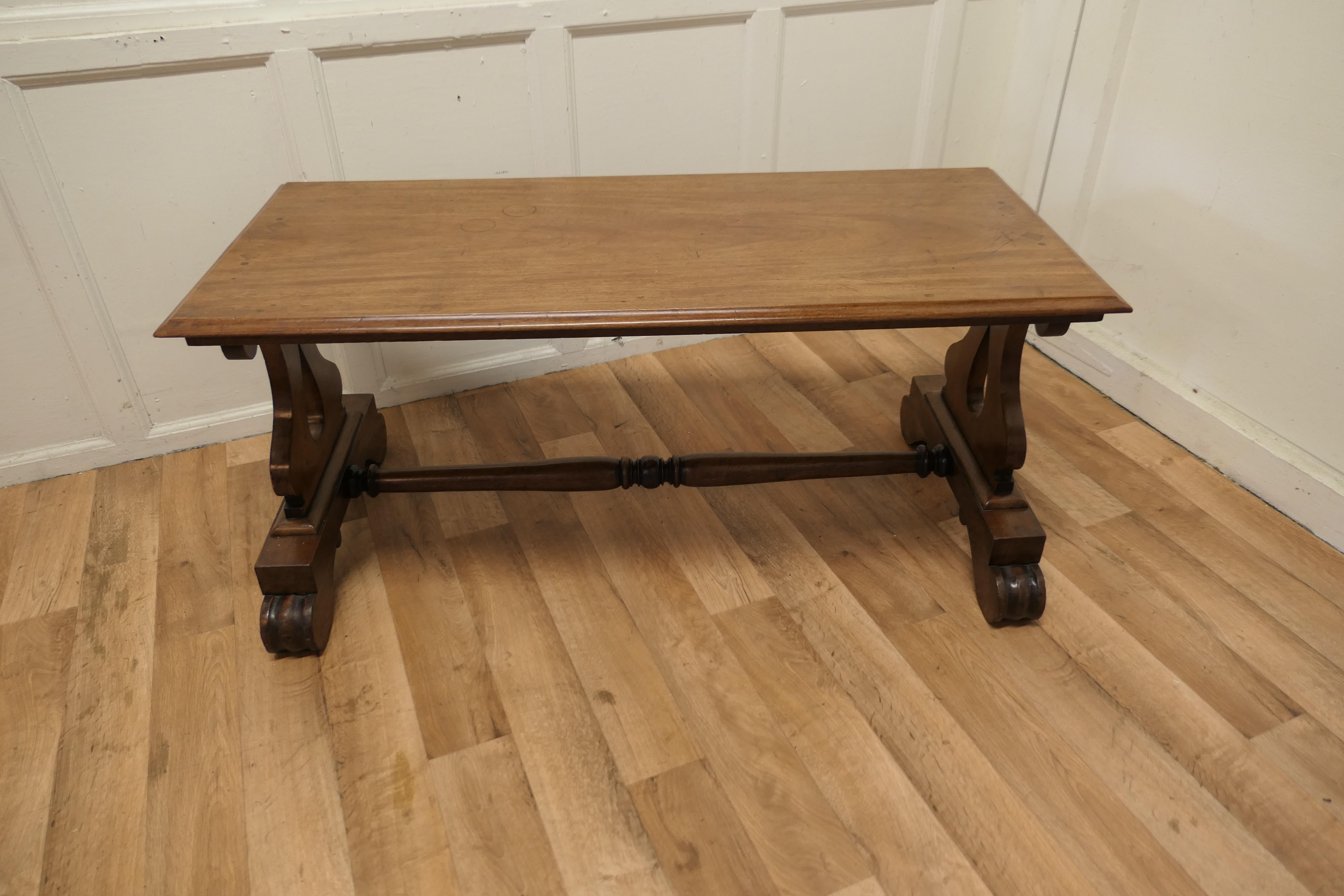 A heavy walnut coffee table

This is a very heavy quality piece it is made in solid walnut with Lyre Shaped Legs and a solid top with a moulded edge
An interesting and good looking piece it is sound and in good used condition with slight marking