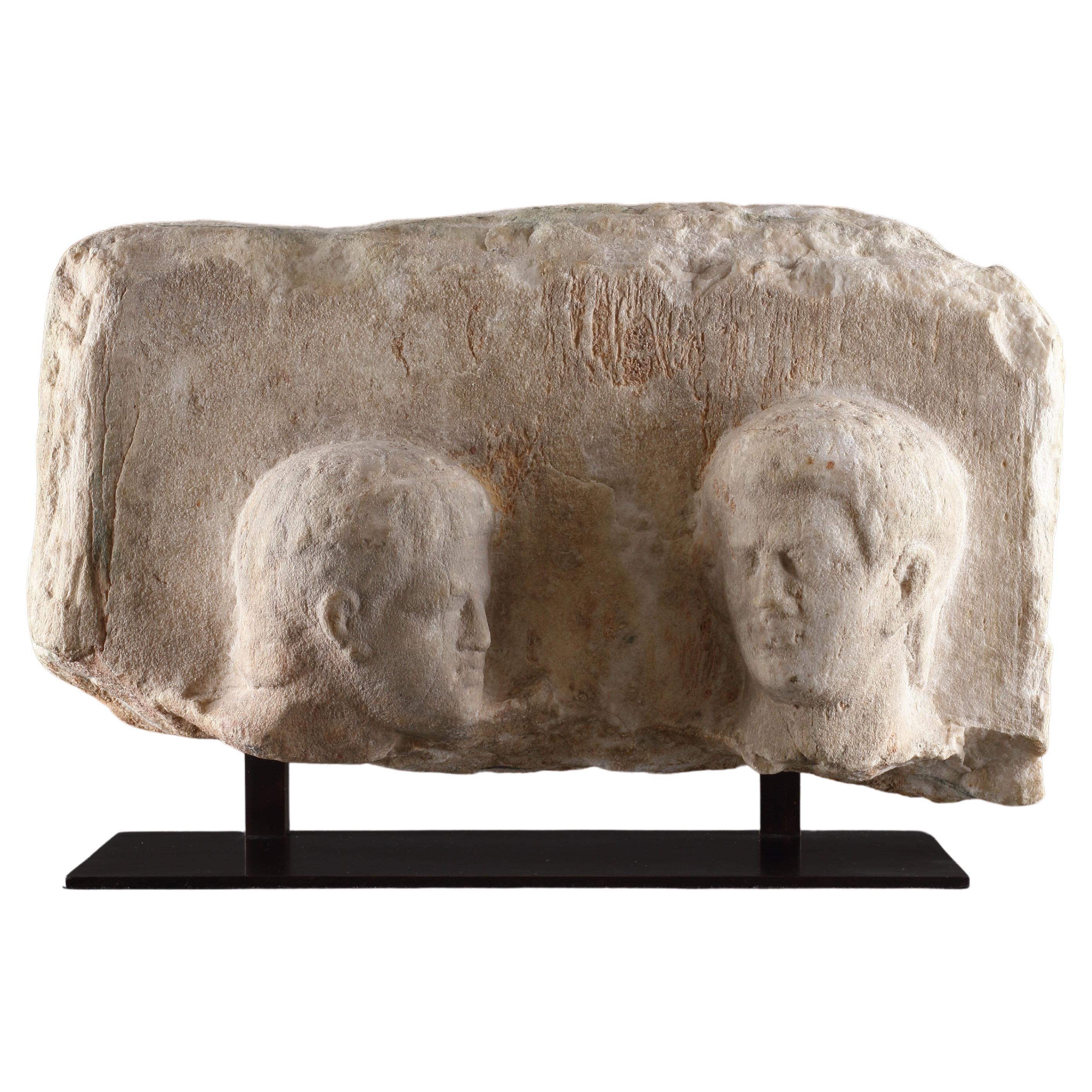 Stele funéraire hellénistique en haut-relief avec deux têtes masculines en vente