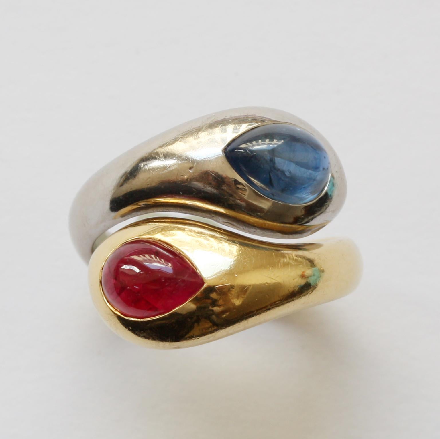 A bi-color 18 carat gold snake ring, half yellow gold with a drop cabochon cut ruby in its head (1.5 karaat) and half white gold with a drop cobochon cut ruby (2.74 carat), by Hemmerle, from München, circa 1980, with its original pouch and
