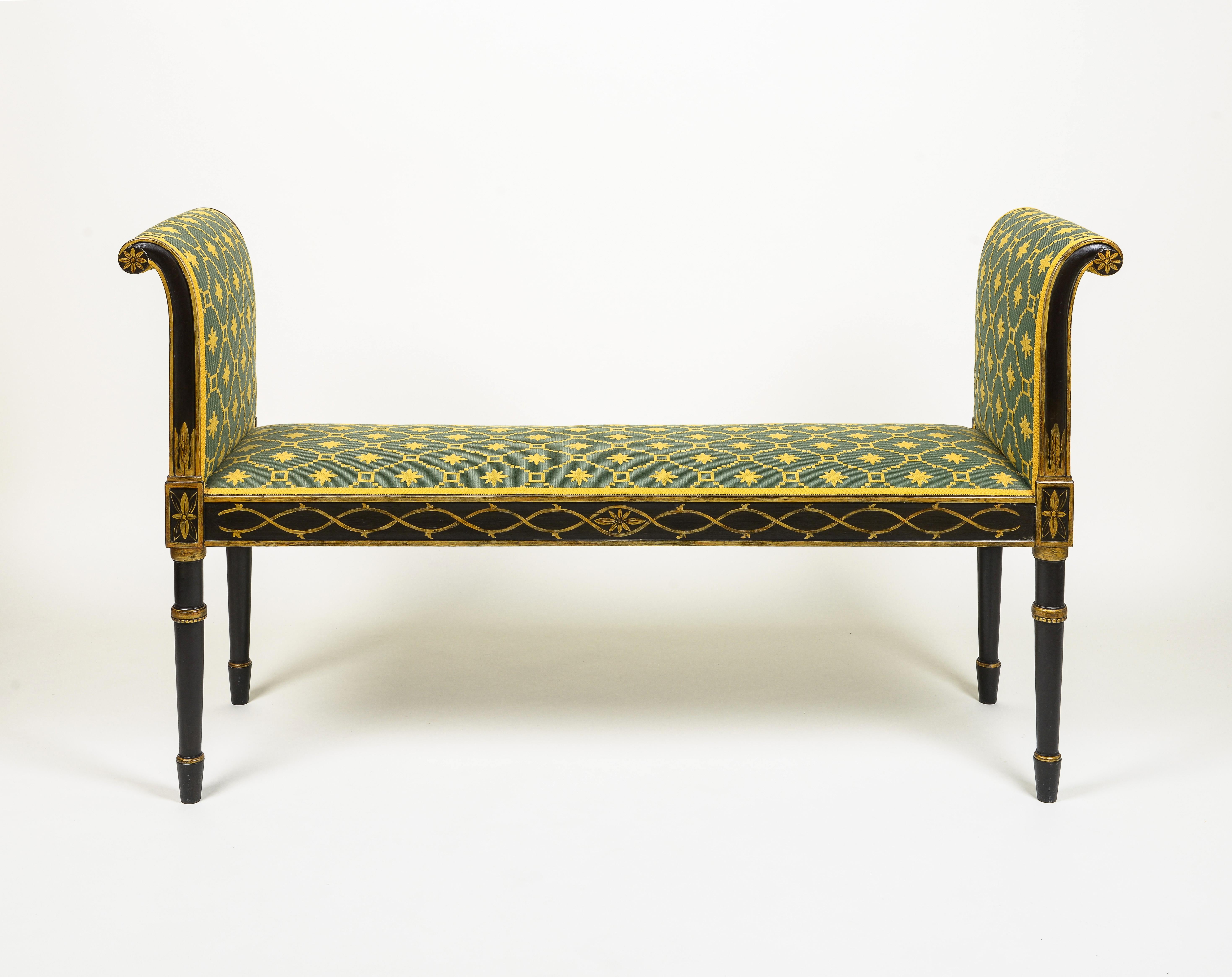 Le siège rectangulaire et les bras à volutes vers l'extérieur sont recouverts d'un tissu néoclassique vert et jaune ; le cadre peint est décoré de feuillages et de volutes entrelacées ; le tout repose sur des pieds tournés et effilés.