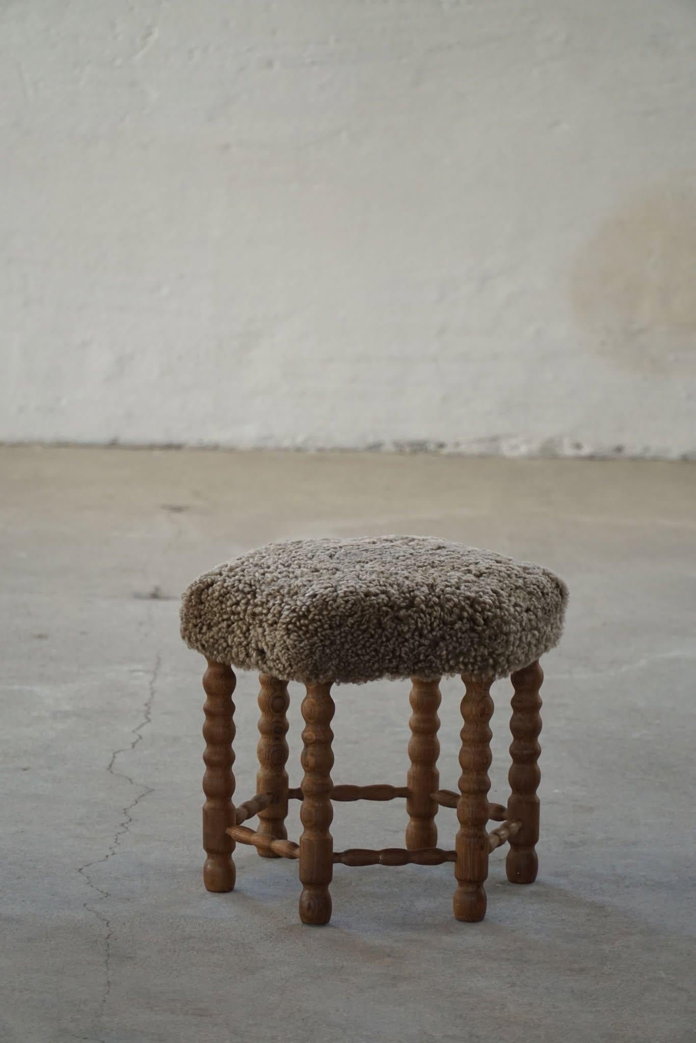 Un hermoso taburete danés moderno de roble con patas rizadas, el asiento hexagonal retapizado en una lana de cordero shearling de gran calidad. Fabricado por un ebanista danés en la década de 1950. Un taburete fino con una impresión intrigante.

Un