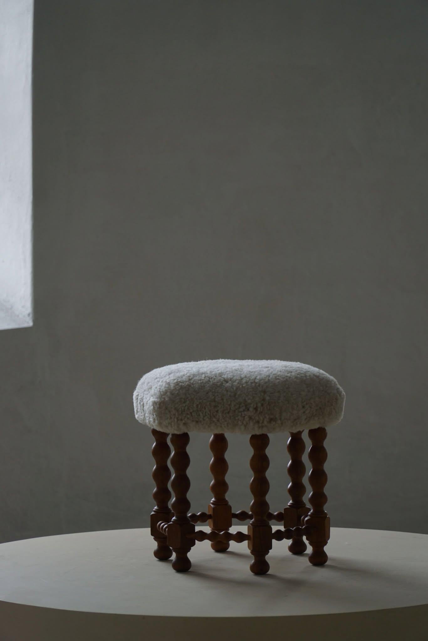 A beautiful Danish modern stool in oak with curly legs, the hexagon seat reupholstered in a great quality shearling lambswool. Made by a Danish Cabinetmaker in the 1950s. A fine stool with an intriguing impression.

A great object for the