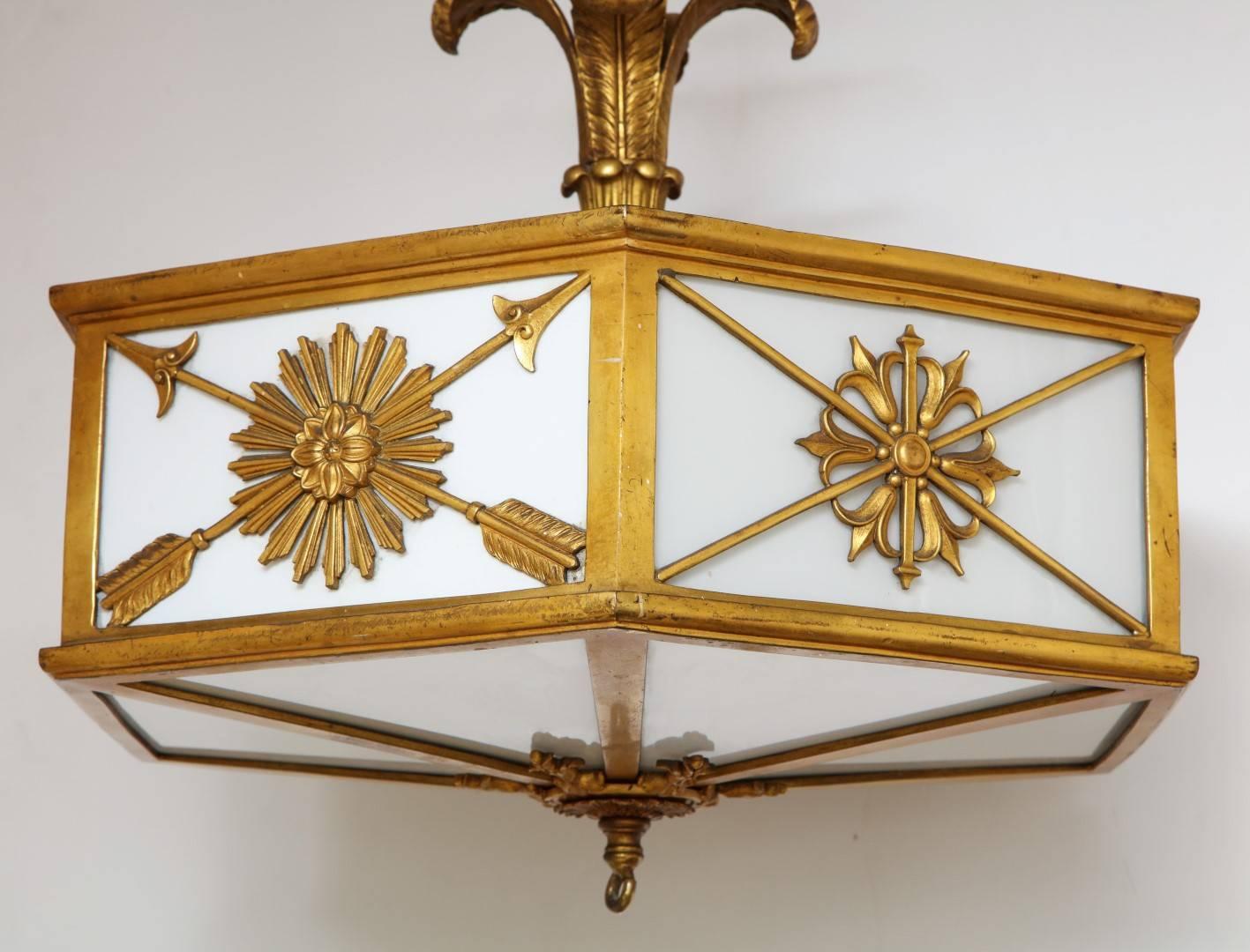 A brass-mounted ceiling, the hexagonal gilt-brass frame with reserves depicting neoclassical motifs, the stem with detailed palm leaves, with six lights. Attributed to Edward F. Caldwell & Co, New York 
