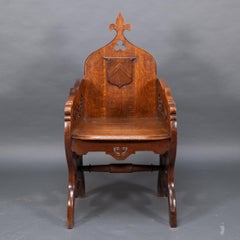 Fauteuil haut en chêne de style Revive gothique, avec des côtés sculptés et chantournés.