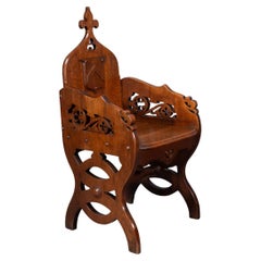 Fauteuil haut en chêne de style Revive gothique, avec des côtés sculptés et chantournés.