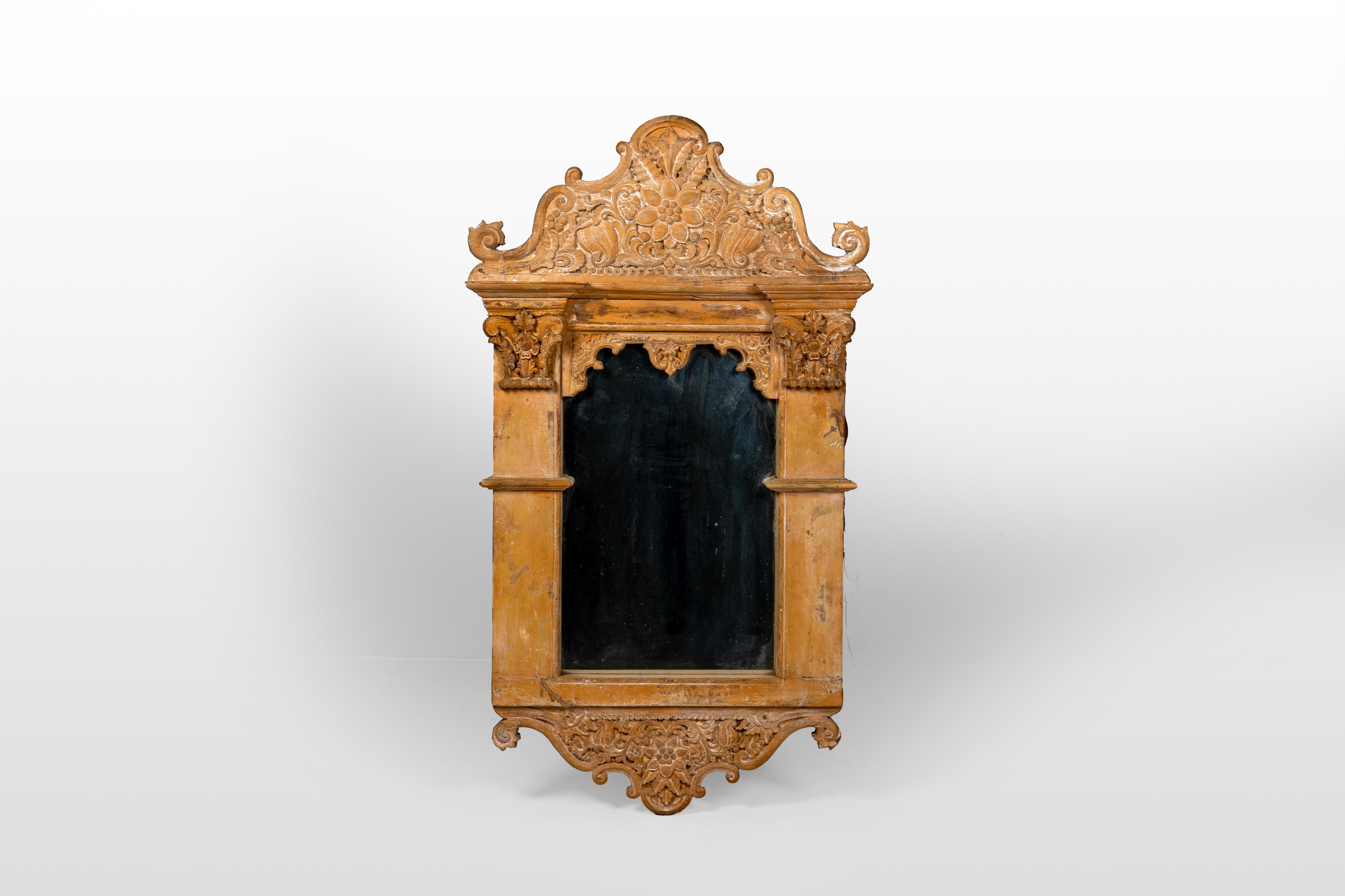 Cette réplique du 21e siècle d'un cadre à miroir INDO- présente une teinte jaune pâle, reflétant le cadre original en grès d'une haveli du Gujarati. Le haut du cadre s'incurve vers le haut, orné de sculptures et de motifs complexes d'acanthe, de
