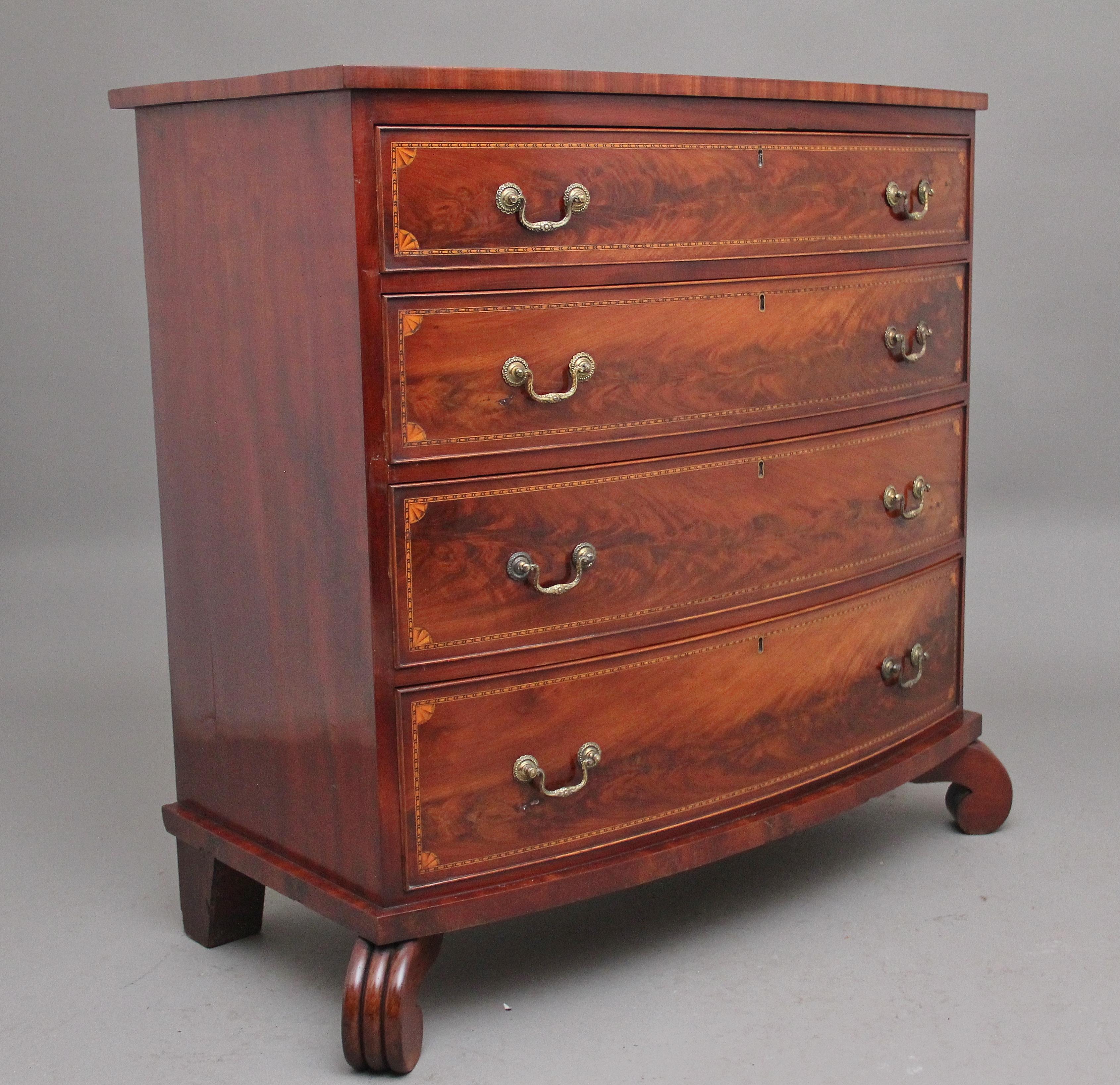 A highly decorative early 19th Century flame mahogany and inlaid bowfront chest of drawers, the figured shaped top above four graduated drawers with brass engraved swan neck handles, the drawer fronts having decorative chequered inlay around the