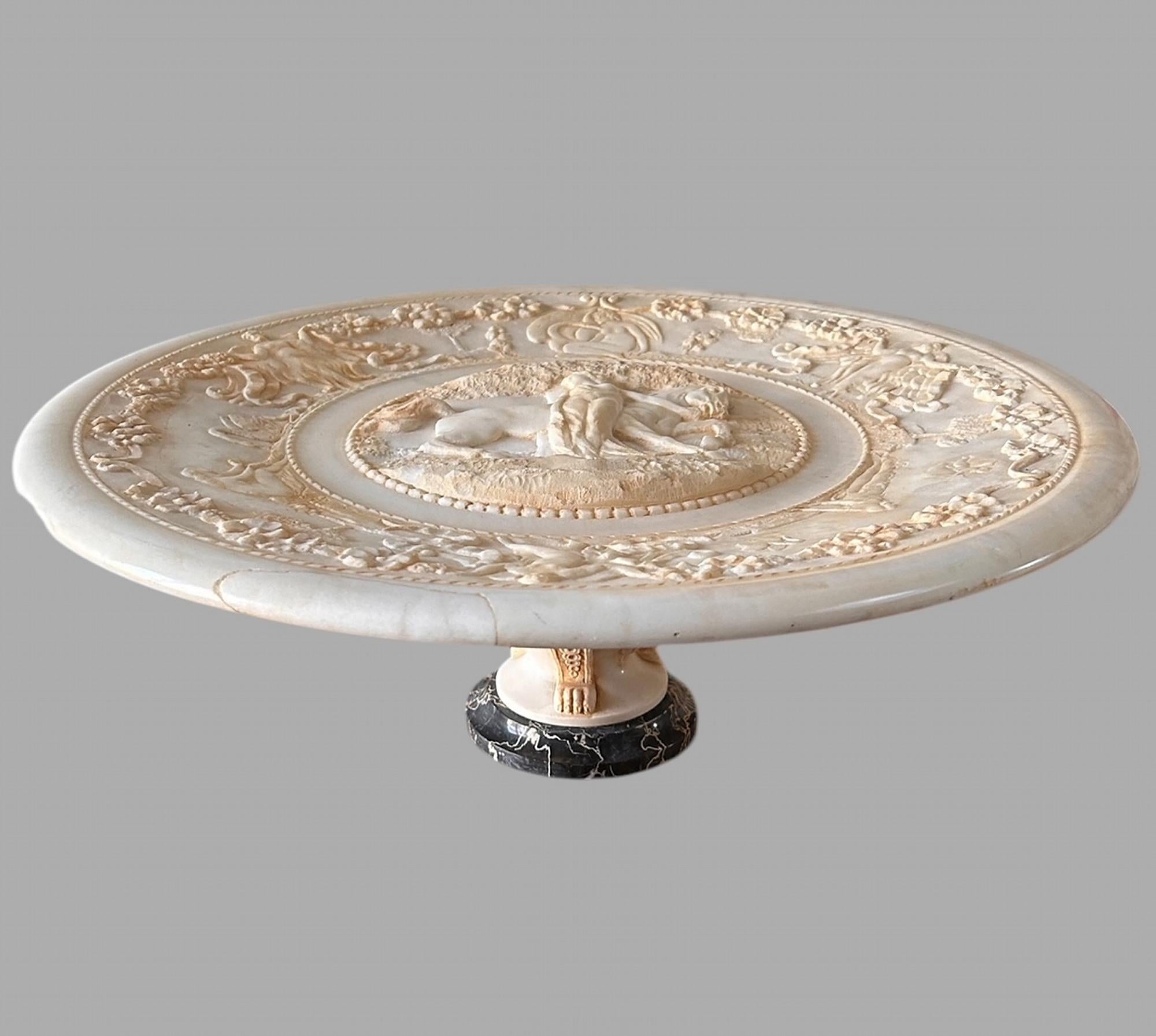 Eine schöne und hochdekorative italienische Marmortazza um 1860 mit einem Durchmesser von 50 cm. Die Tazza selbst ist stark verziert mit dem Zentrum einer Frau, möglicherweise einer Gottheit oder einer allegorischen Figur mit einem Pferd, und die