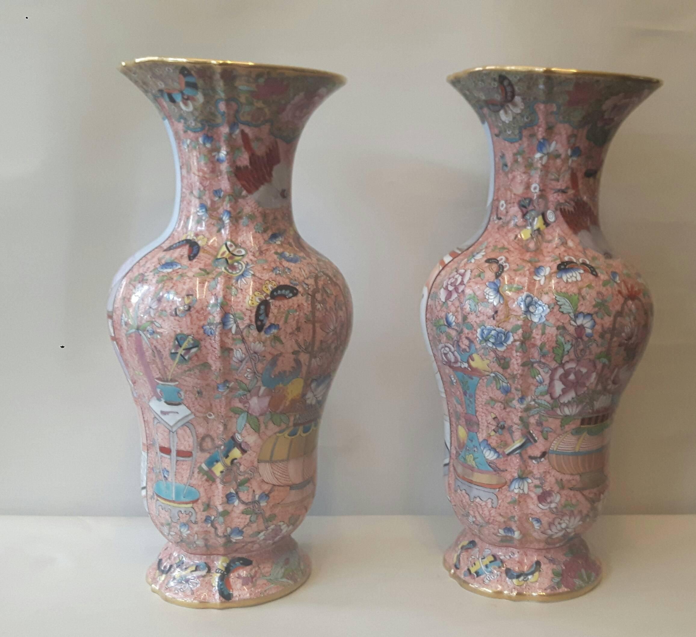 An impressive pair of chinoiserie Samson vases imitating the famille rose design, hand-painted with scenes of court life, overlooking a lake. The back of the vases are elaborately painted with flowers, butterflies and good luck charms on a rose