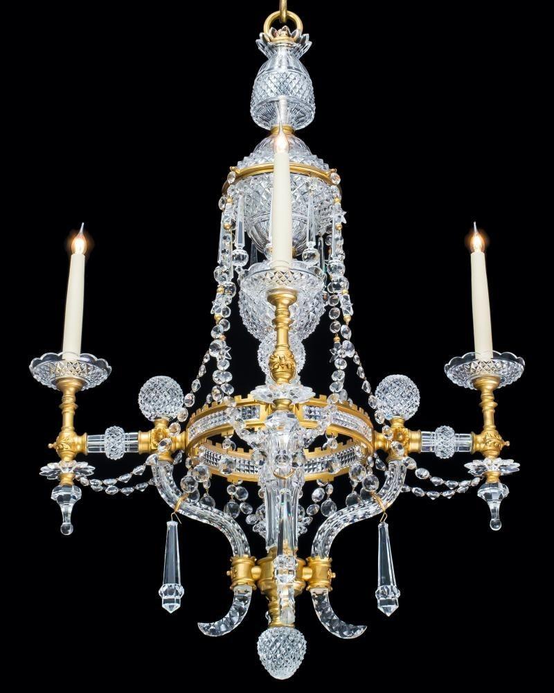A most unusual ormolu mounted cut glass chandelier with diamond cut stem issuing four arms with scroll tails supporting the main band of crenellation form inserted with diamond cut panels, the arms mounted with diamond cut spheres and columns