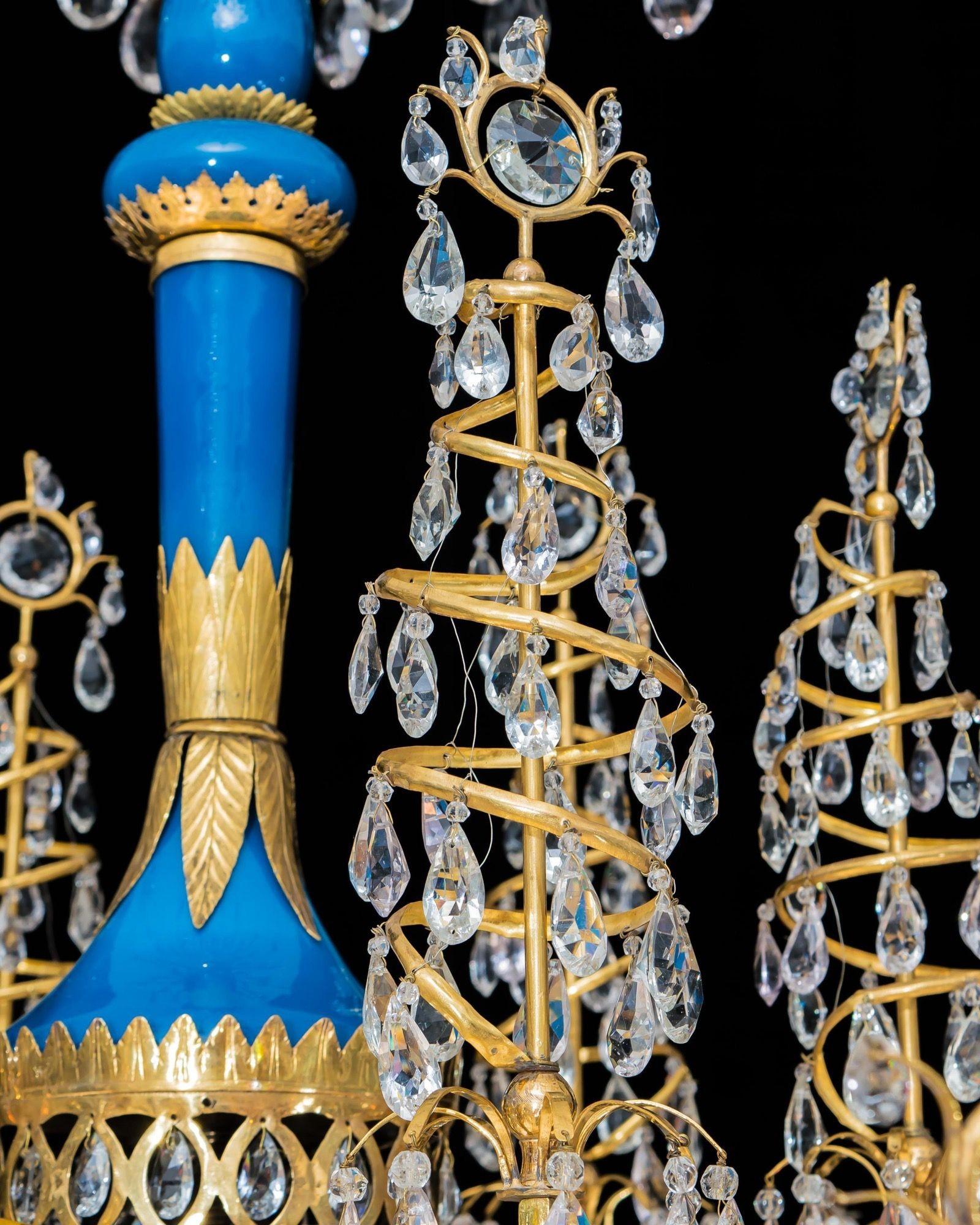 A highly impressive, eighteen light ormolu mounted and cut glass chandelier. The turquoise opalescent baluster stem with foliated mounts supporting a reed corona and the central vase issuing six arms supporting spiralled obelisks. The finely chased