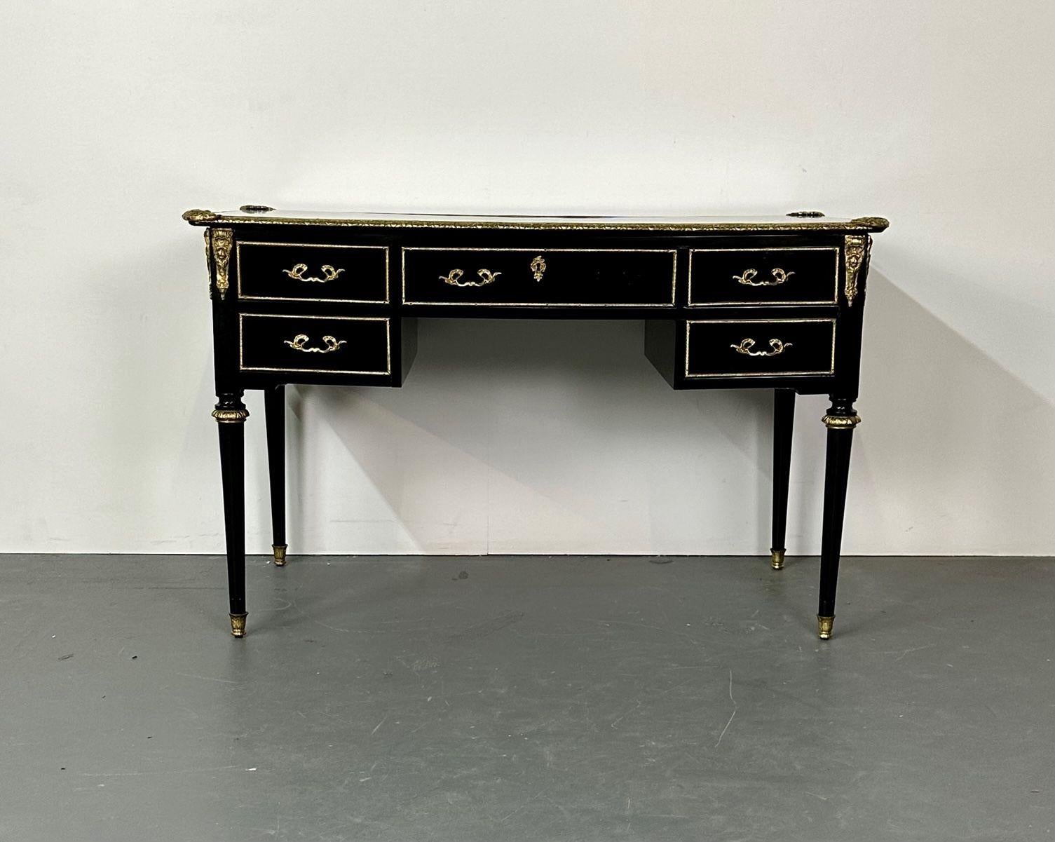 A Hollywood Regency Ebony and Bronze Mounted Desk, Writing Table or Vanity. One of a pair. 
A stunning example of this highly sought after designers work. Bronze sabots and capitals shine on the sleek tapering legs with flame bronze mounts on the