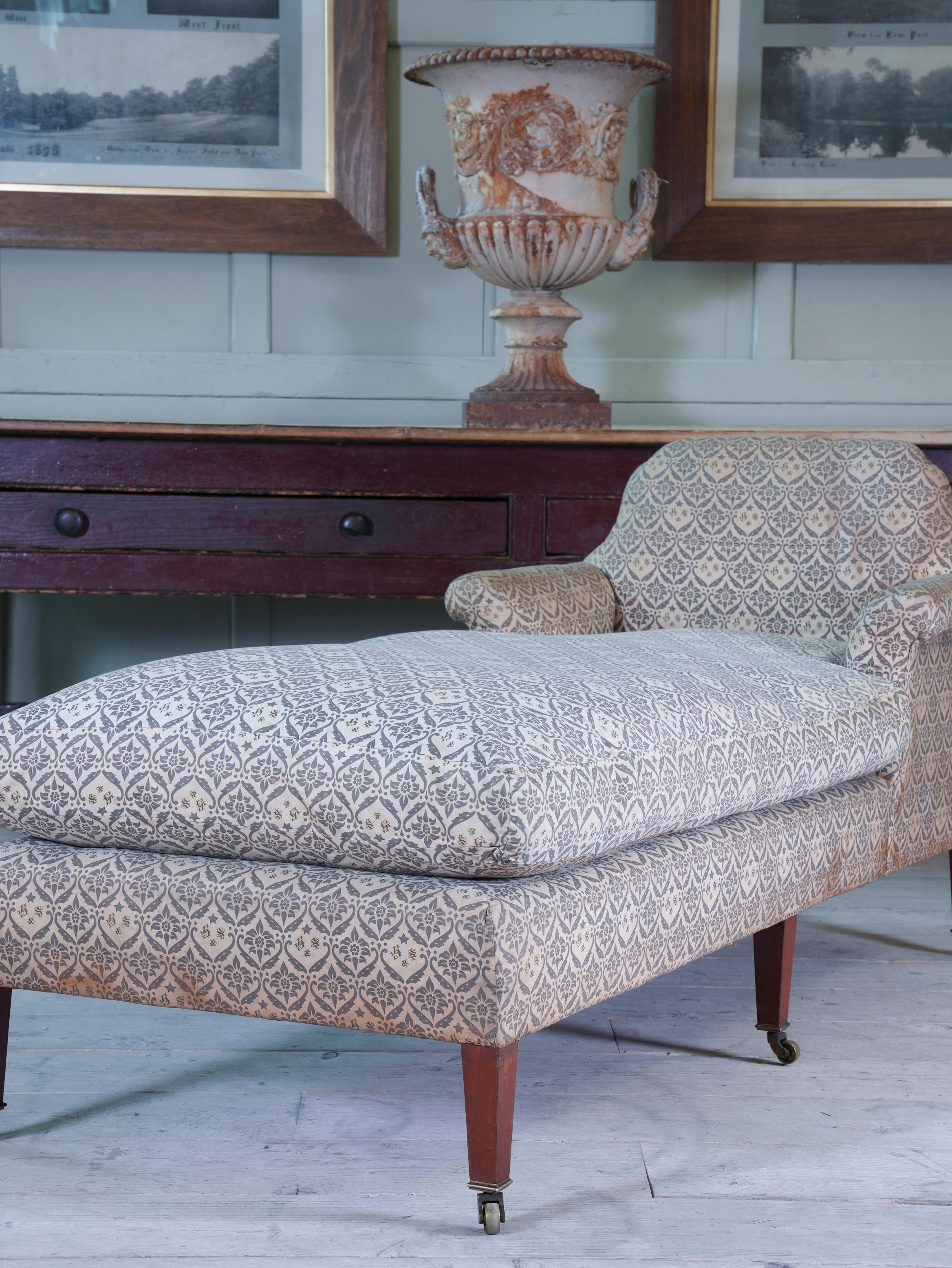 Upholstered in its original Howard & Sons monogrammed ticking, raised on mahogany square tapering legs showing the factory stamps, factory marked brass castors are also all original.

The underside showing the stencilled 
