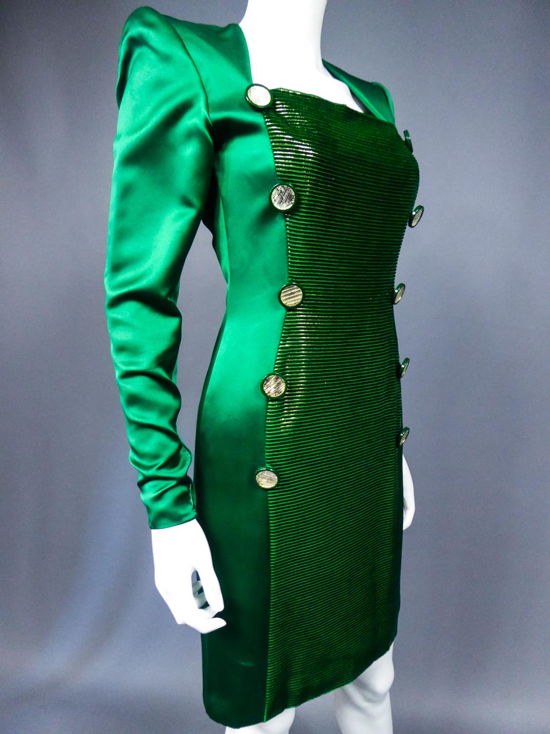 Circa 1985
France Haute Couture

A Hubert de Givenchy dress for show in emerald silk satin and gold lamé velvet dating from 1985/1990. Straight dress slightly skin-tight and long sleeves with huge shoulder-pads. Long dickey in ribbed velvet and lamé