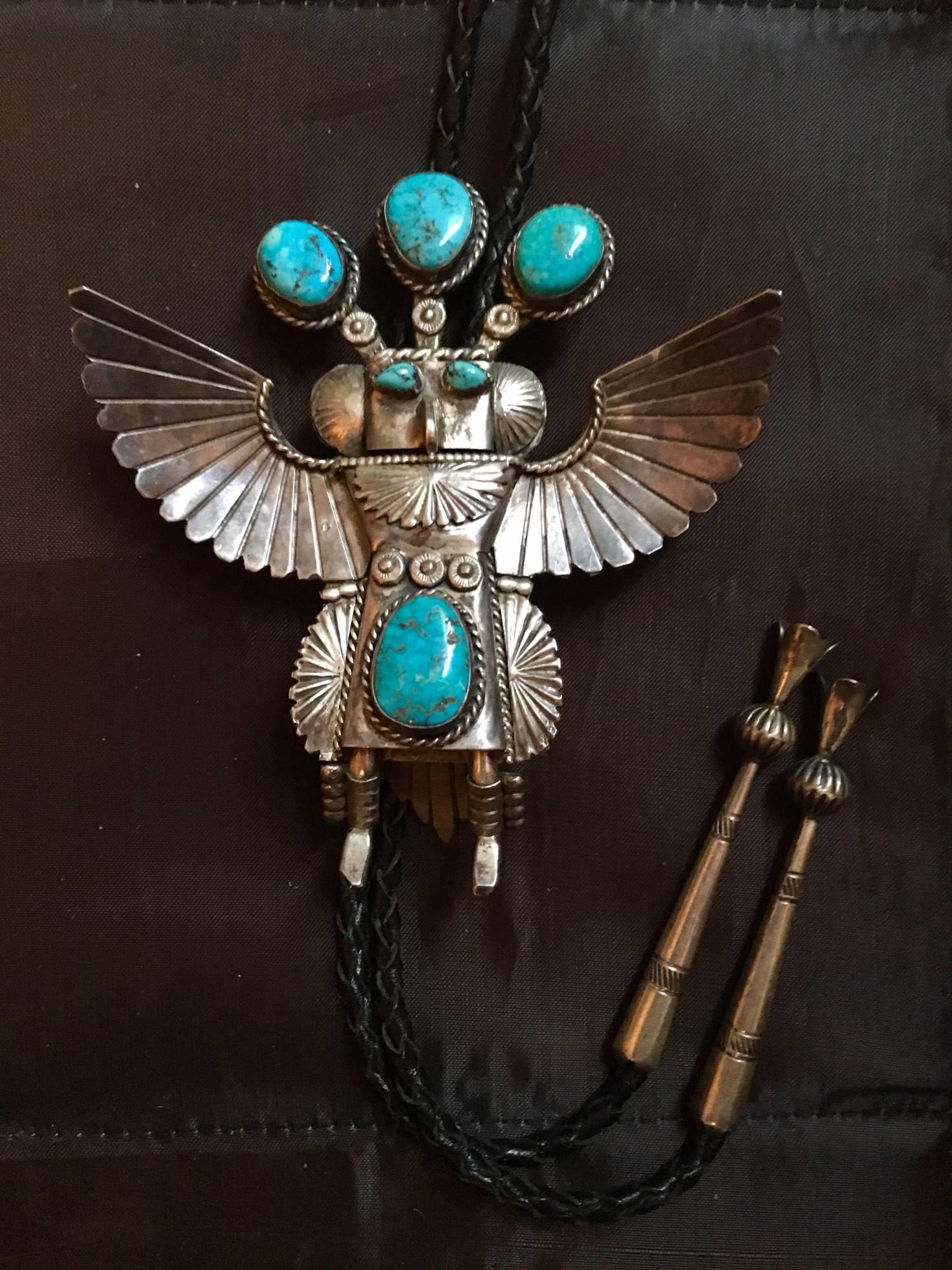 This is a Majestic Bolo tie, depicted as a Kachina, this bolo tie has four large irregular hand-cut turquoise (the largest measuring 3/4”) and two smaller stones set in a pie crust surround depicting eyes of the Indian. The main subject Indian with