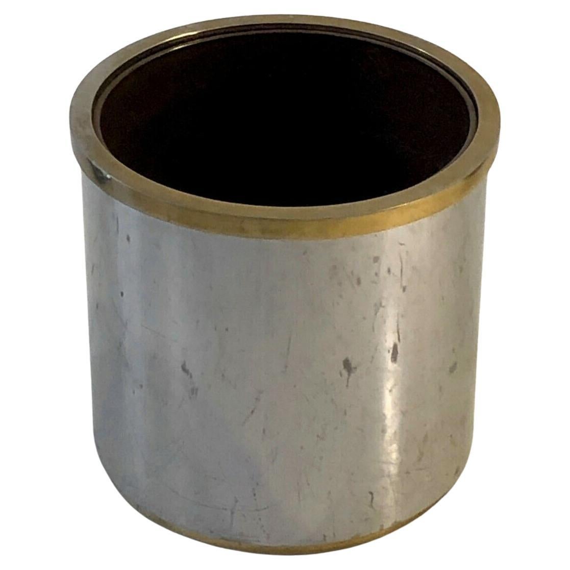 An elegant and generous cylindrical planter with a golden border, Art-Deco, Modernist, Shabby-Chic, in mirror polished steel enhanced with a golden square section border, brown plastic inner pot, Jansen edition, France 1970-1980.

DIMENSIONS: H 39.5