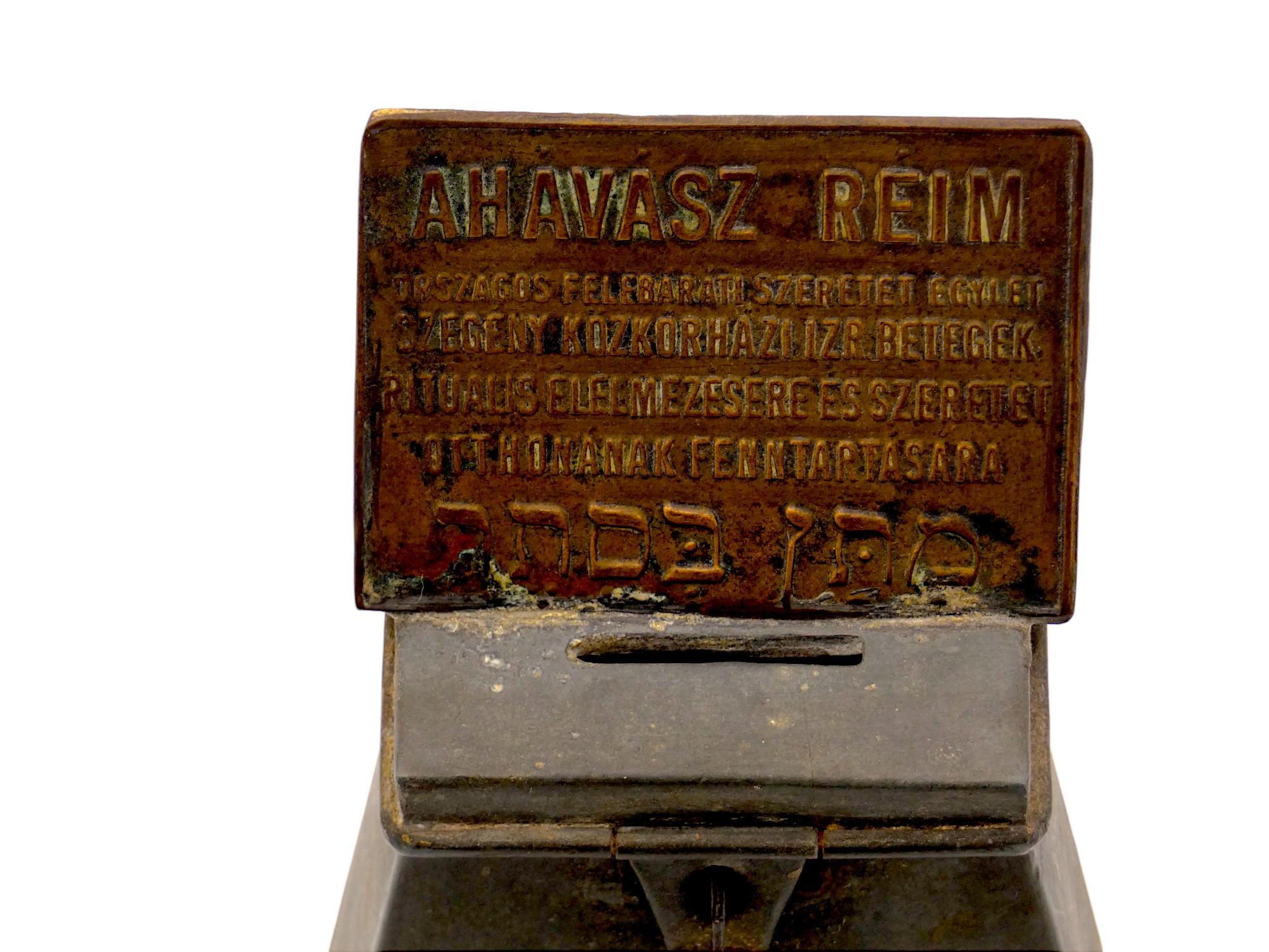 A  Rare Hungarian Tin Charity Container made in the late 19th Century.

Charity box has a latched cover at the top and a plaque informing the people who donate to the box which organization they are donating to.

Plaque at the top written in 