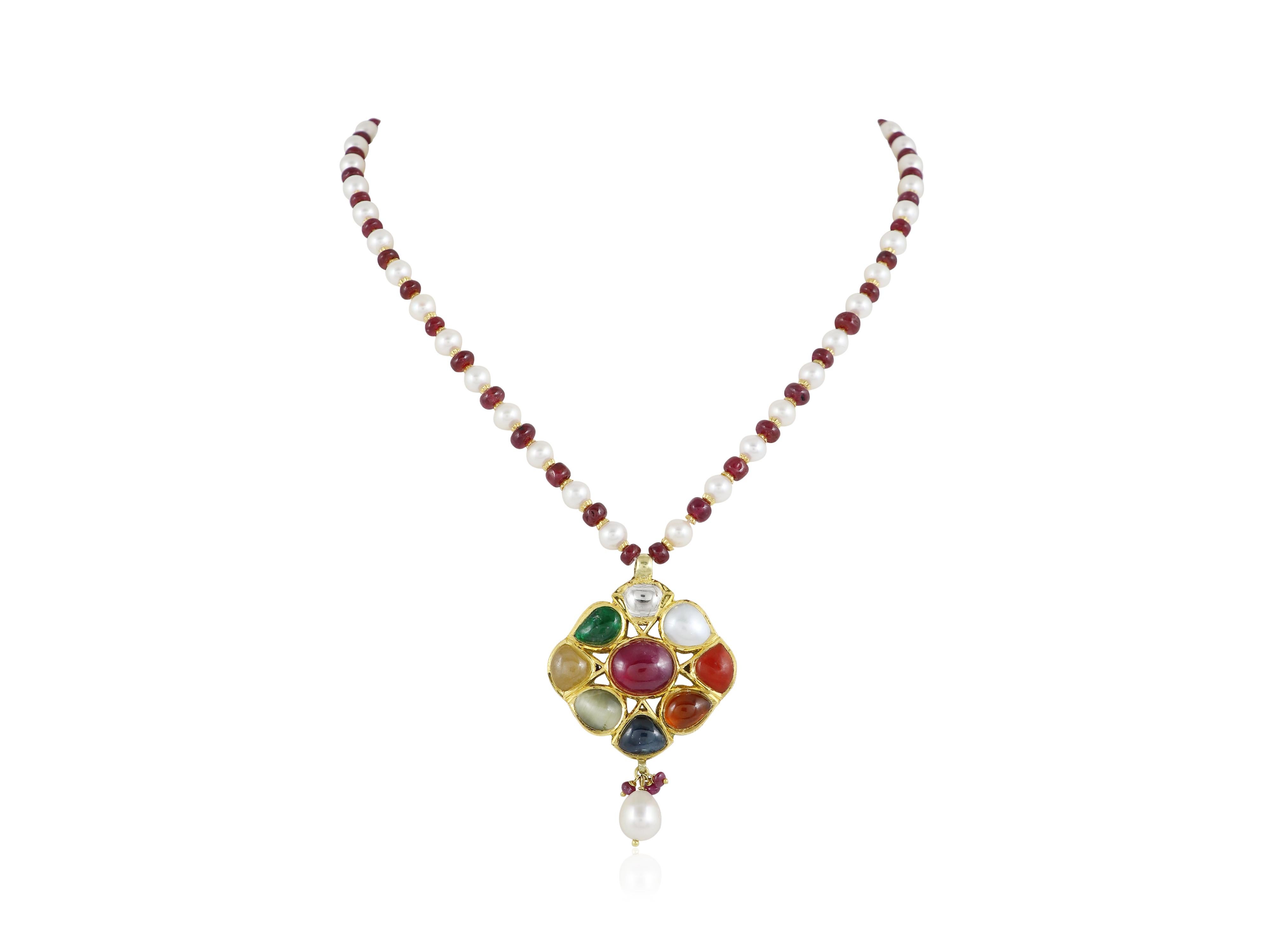 Presenta un raffinato pezzo di eleganza indiana: questo pendente Navratan in oro 18 carati è un'espressione compatta ma potente della ricchezza culturale e dell'armonia spirituale. Incastonato con le nove gemme sacre del Navratan - ognuna delle