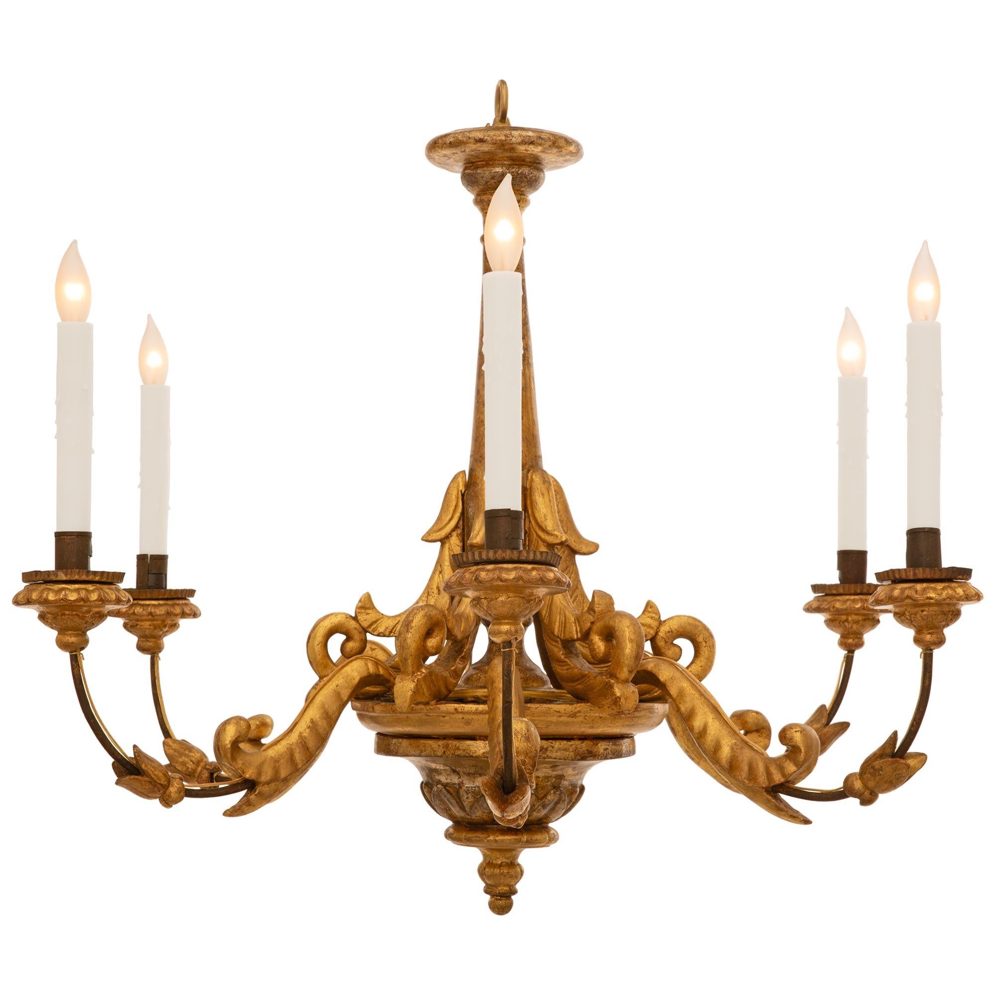 Un attraente e decoratissimo lampadario barocco italiano del XVIII secolo in legno dorato, ferro e mecca. Questo bellissimo lampadario a sei bracci è centrato da un terminale inferiore in legno d'orato a forma di topie che si trova sotto il corpo
