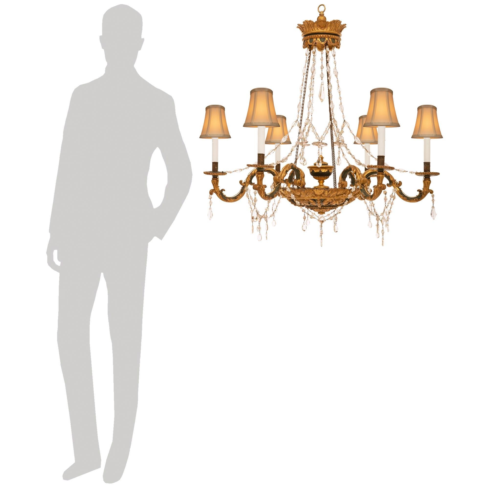 A stunning and most decorative Italian 18th century Louis XVI period patinated green, Giltwood, and glass chandelier. This impressive six arm chandelier is centered by a circular Giltwood and patinated green bottom dome with scrolling acanthus leaf