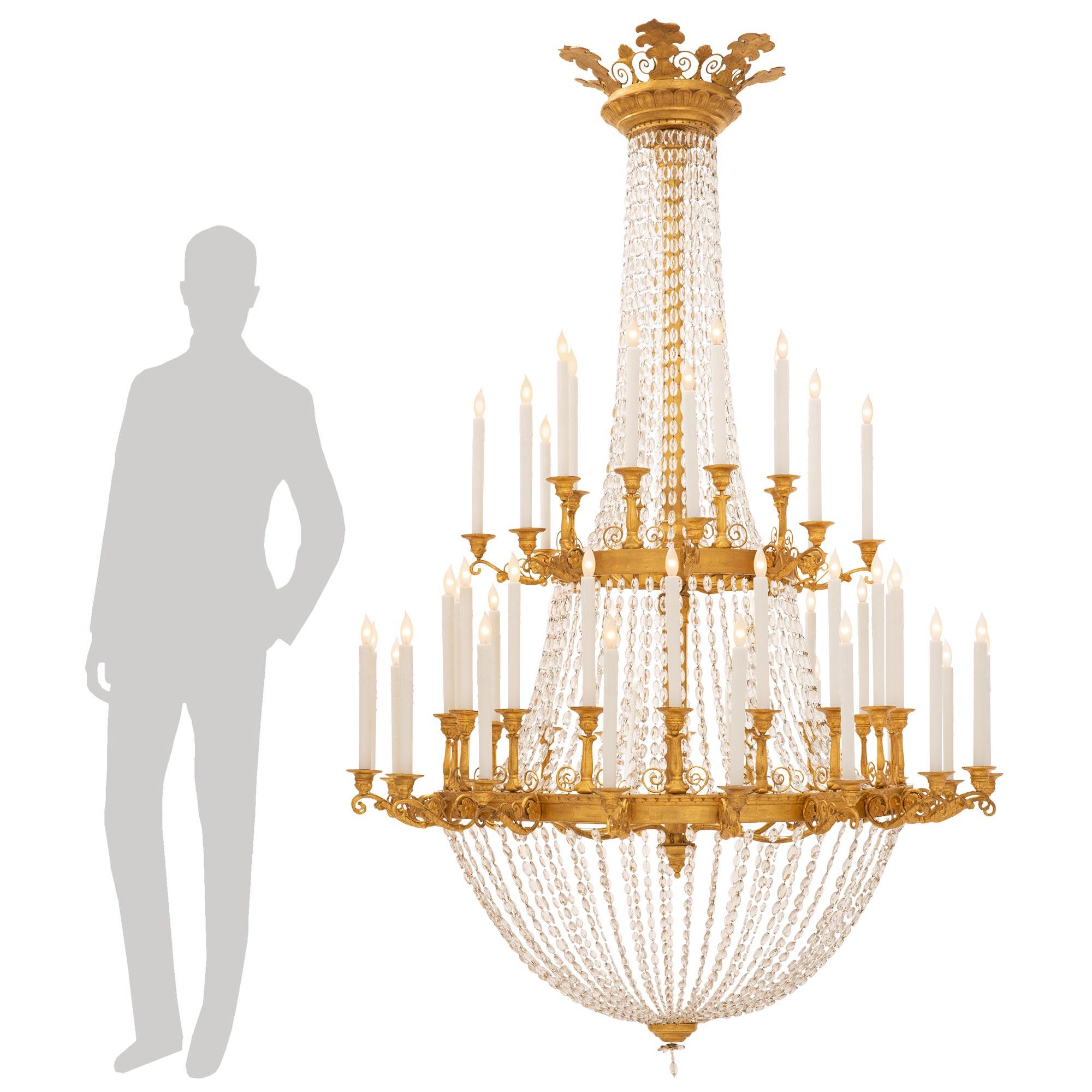 






Superbe lustre néoclassique italien du XVIIIe siècle en bois doré et cristal. Le lustre à deux niveaux et cinquante-deux bras est centré par un charmant fleuron inférieur en cristal et une réserve circulaire en bois doré tacheté, d'où un