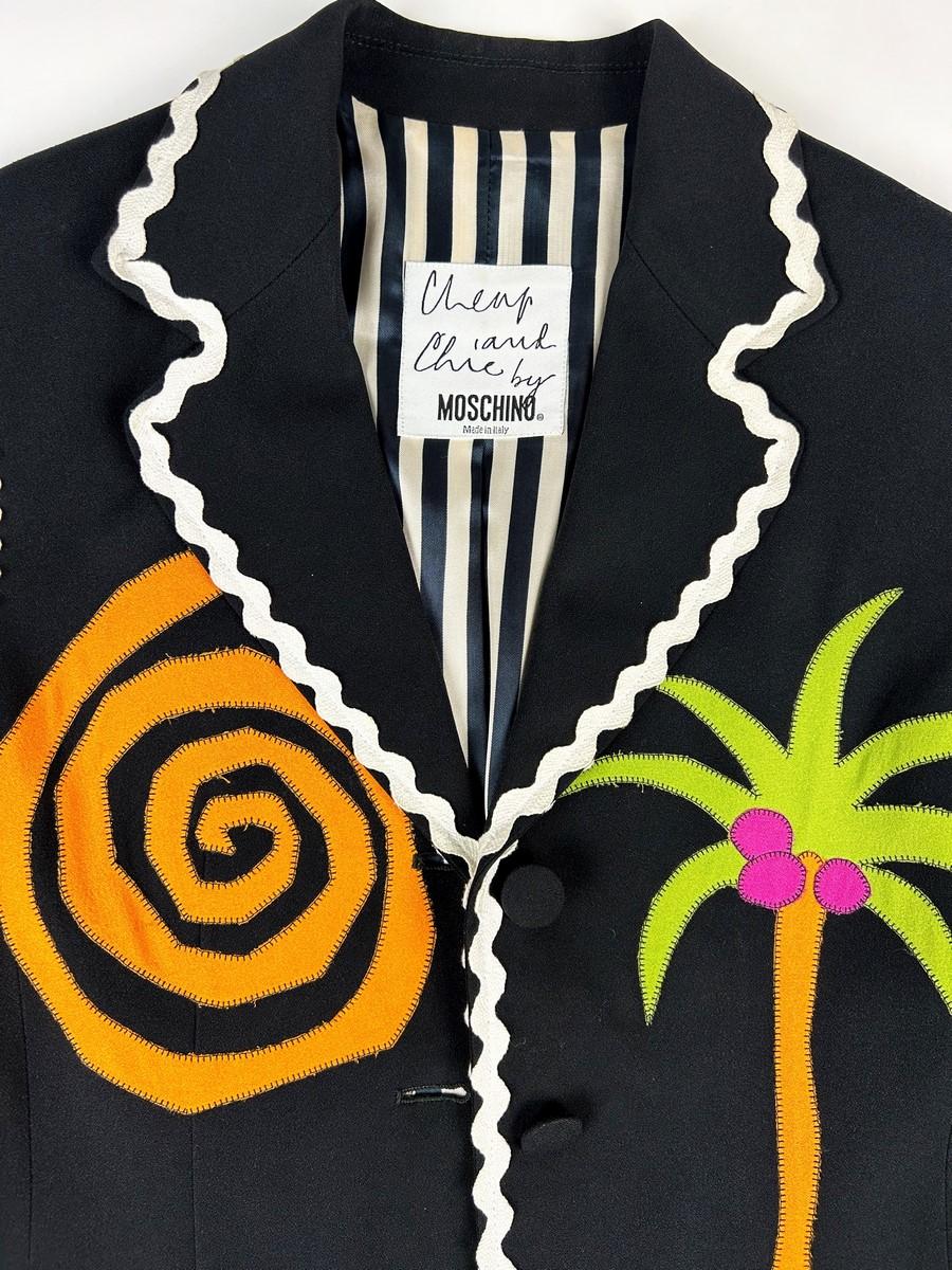 Circa 1990-1992

Italy

Iconic Cheap and Chic by Moschino jacket from the most creative period of Franco Moschino, who died in 1994. Slim-fit jacket in black acetate crepe with folded-down collar and long sleeves. Fully piped with white cotton