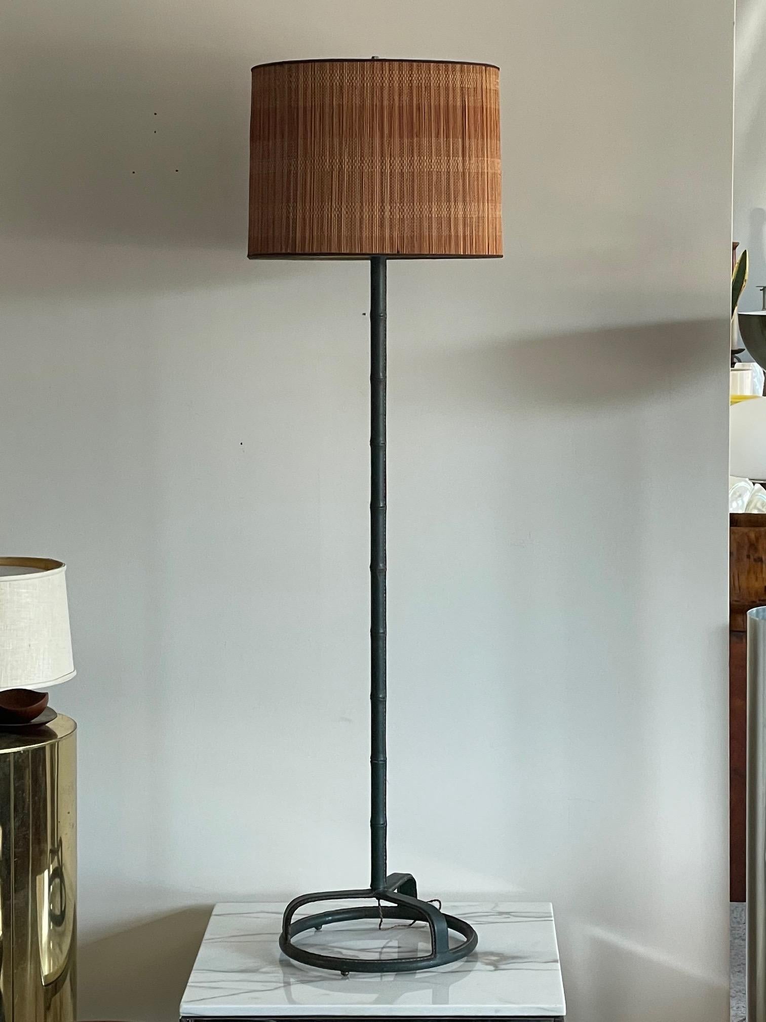 A classic Jacques Adnet floor lamp in original dark green leather. Note the unusual tripod in a circle base. Rewired.