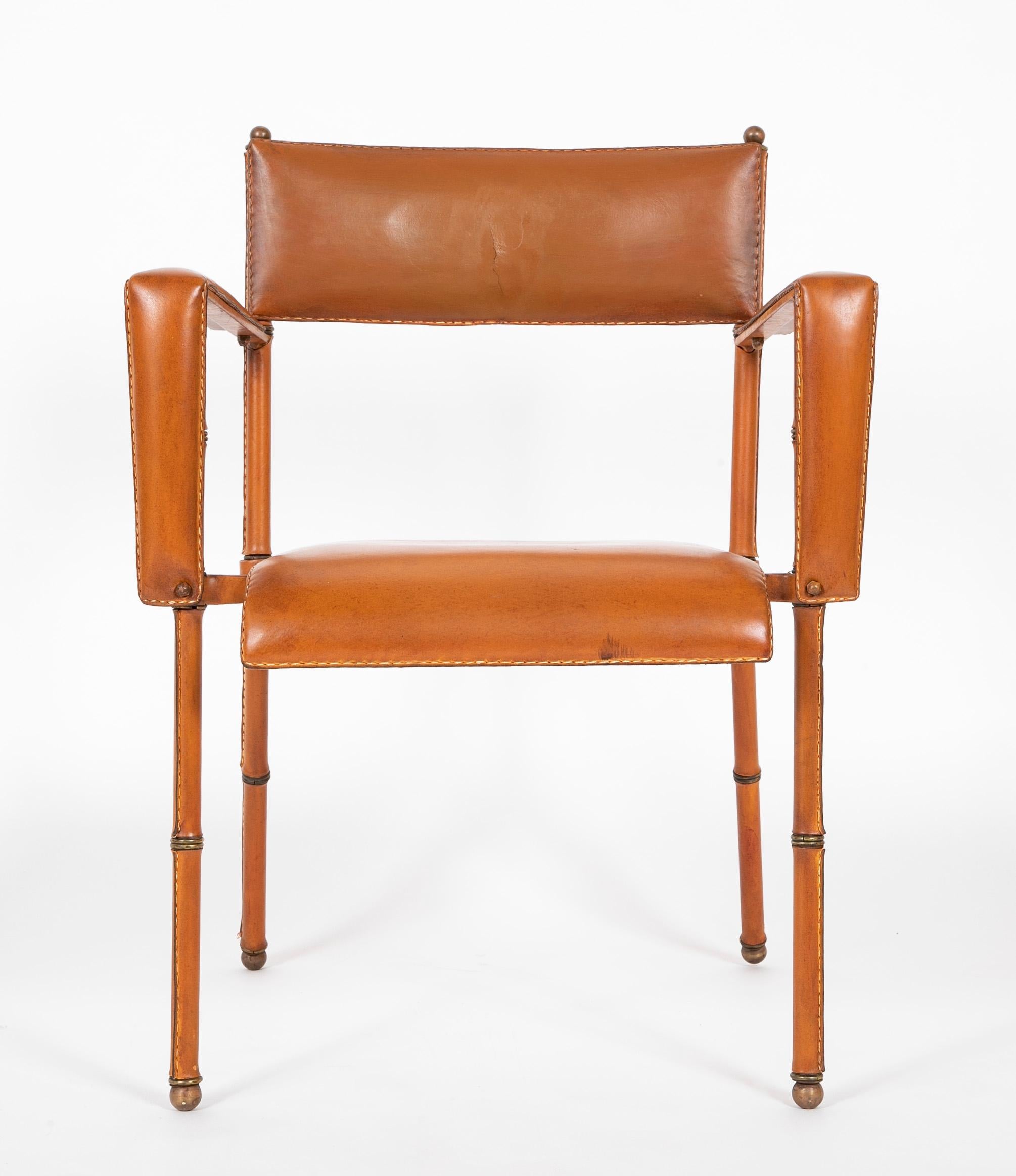 A hand stiched leather desk chair by French designer Jacques Adnet. featuring a tubular steel frame, upholstered with patinated leather. Adnet introduced the frame in combination with leather, which was an ingenious move; maintaining the avant-garde