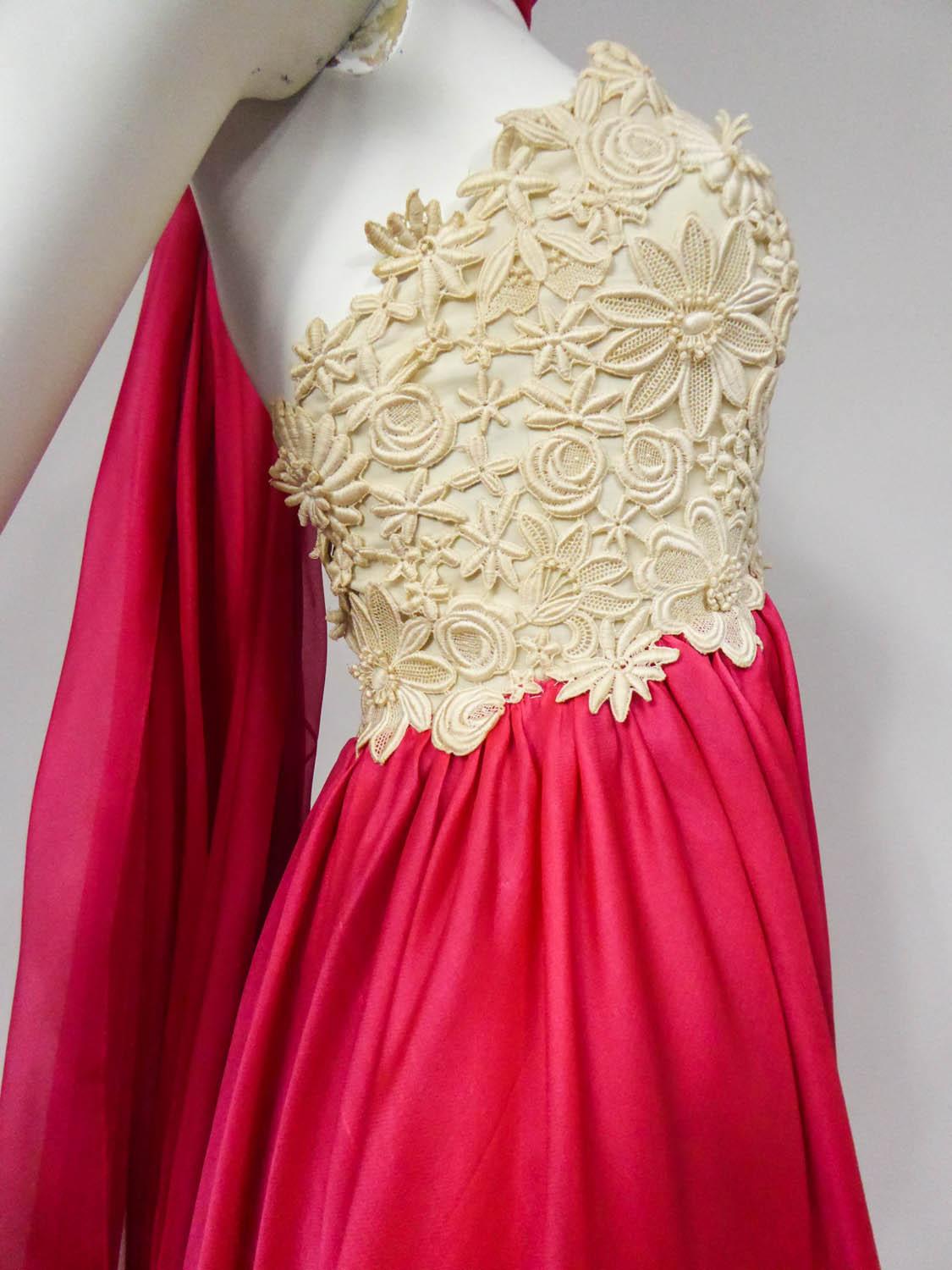 Circa 1958/1960 Frankreich
Jacques Griffe Haute Couture Kleid aus cremefarbenem Guipure und fuchsiafarbenem Organza-Musselin aus den späten 50er Jahren. Silhouette in der Nähe der Linie Tonneau Balenciaga mit seiner hohen Taille und geneigten Rücken