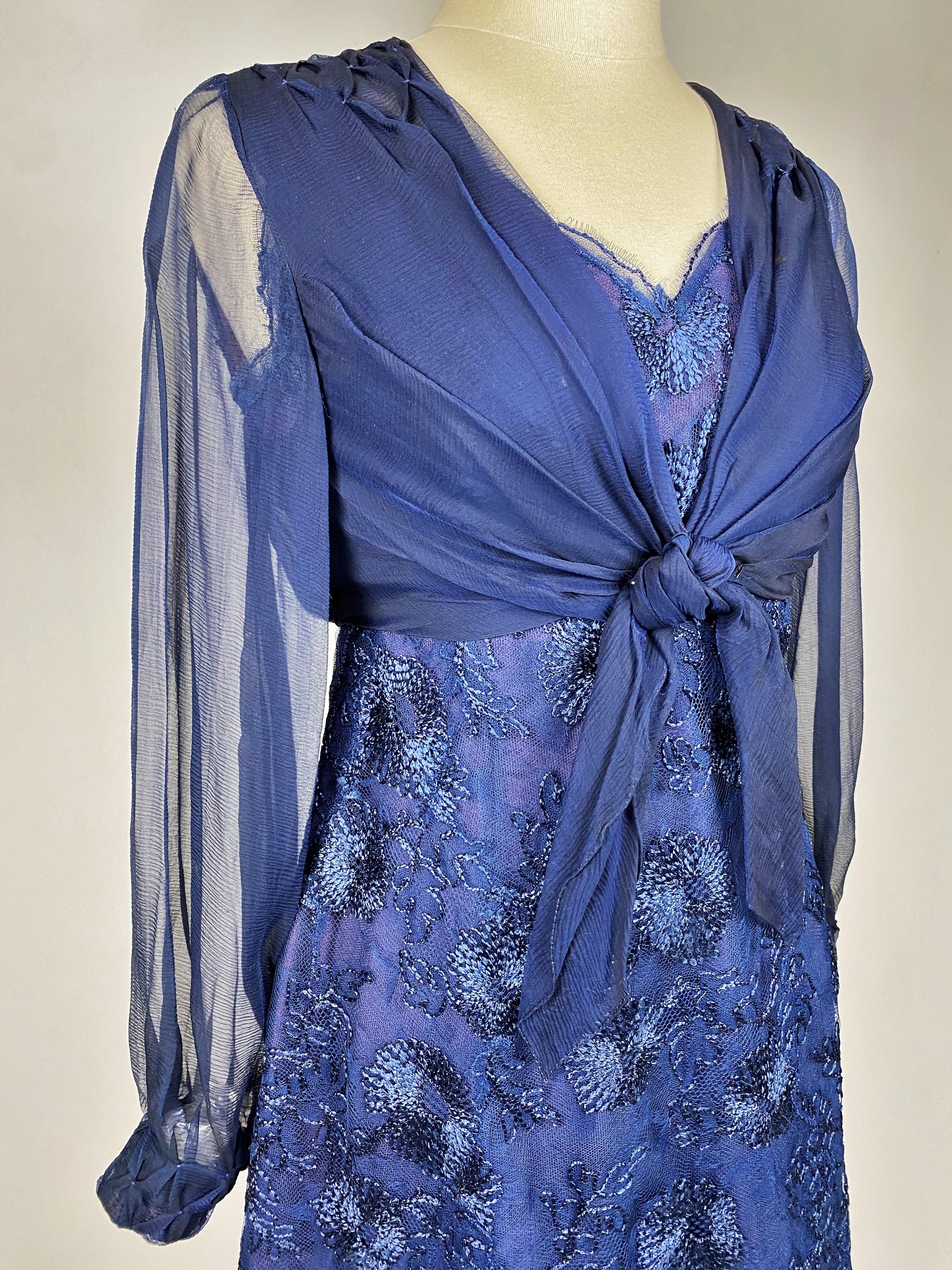 Ca. 1965
Frankreich
Cocktailkleid aus marineblauem Seidentüll mit Flochenseidenstickerei und Bolero von Jacques Heim Jeune Fille unter der Leitung von Jacqueline Citroën aus den 1960er Jahren.  Kurzes Kleid, ärmellos, V-Ausschnitt und Reißverschluss