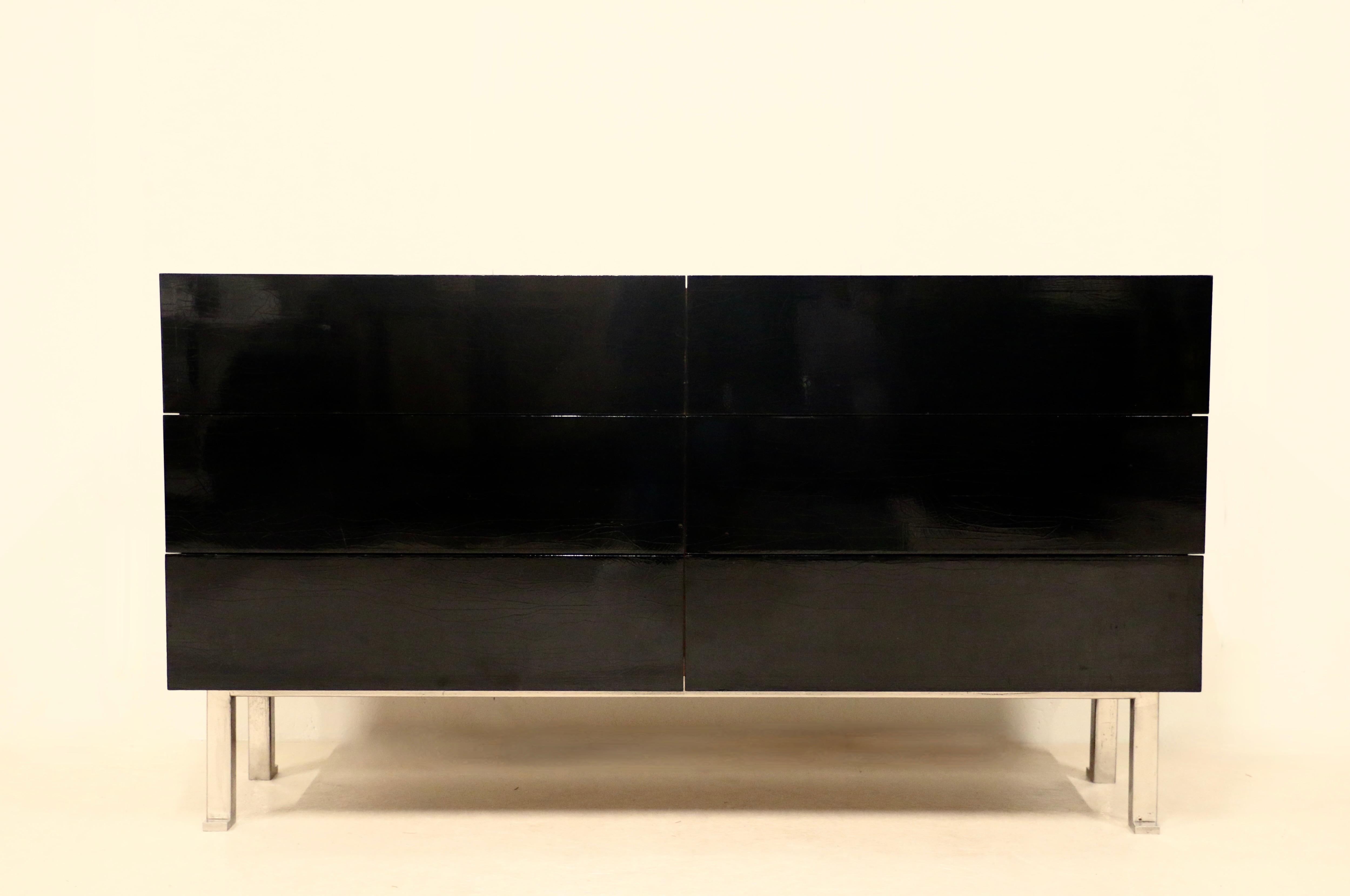 A large chest of drawers with six overhanging drawers in black lacquer. The top and sides are in Rio mahogany and the base in cast aluminum. Jacques Quinet ( 1918-1992 ) France, 1950s.