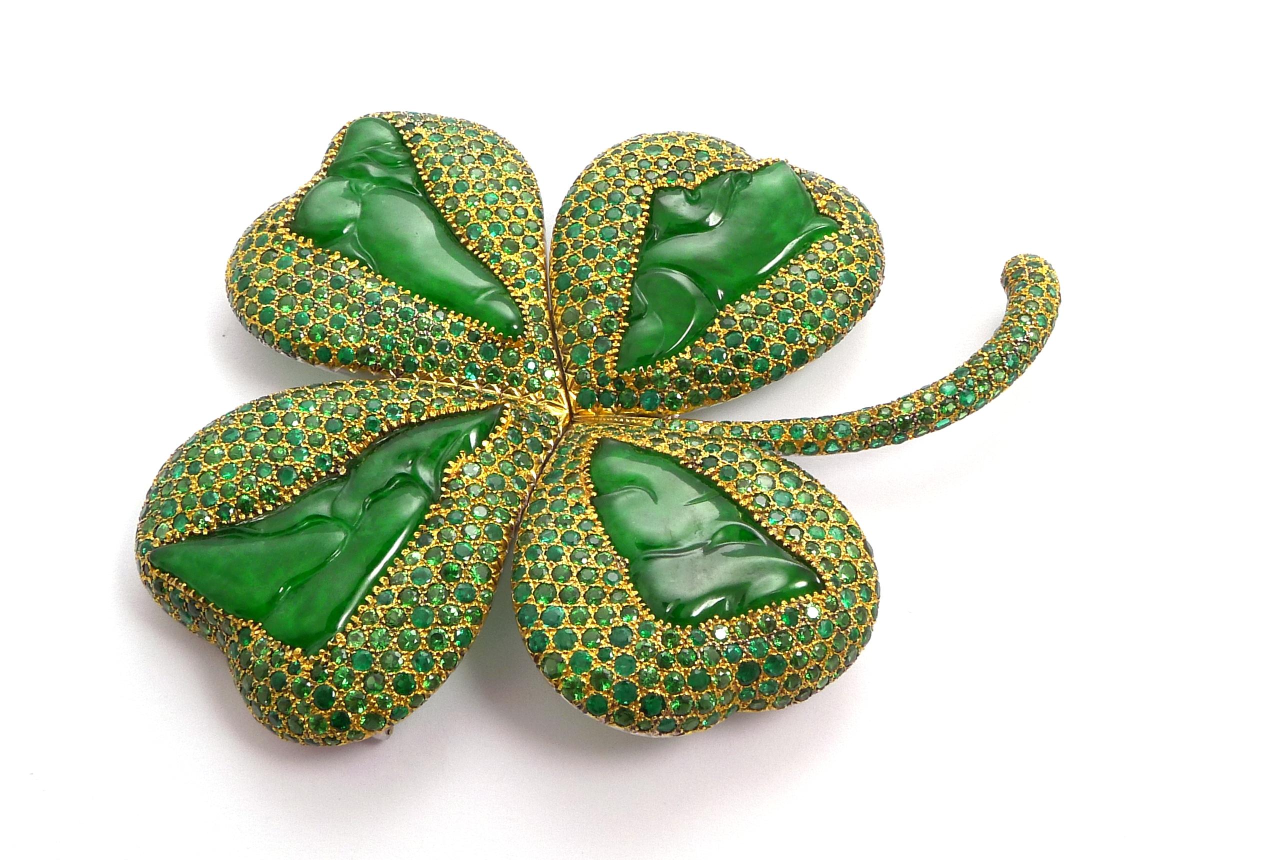Modelled as a gold four-leaf clover pavé-set with round emeralds and tsavorite garnets, enhanced with four carved jade plaques

Mounted in 18K yellow gold

- 4 carved jade plaques: 28.30 ct total
- 375 round emeralds: 14.77 ct total
- 576 round