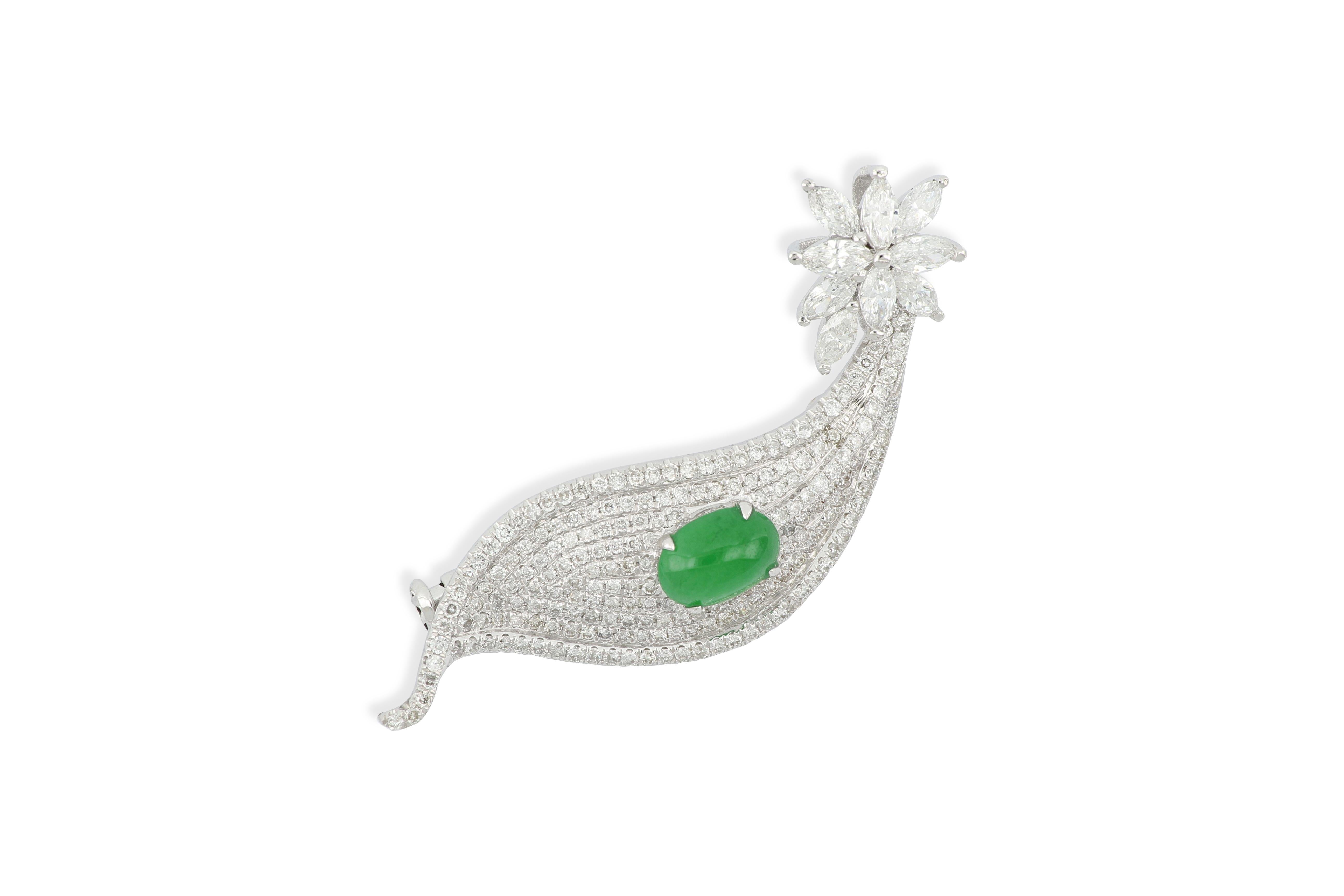 The magnificent brooch in a leaf shape featuring a translucent oval natural jadeite cabochon of bright emerald green colour, decorated with pear shape, marquise and brilliant-cut diamonds weighing 1.33 carats in total, mounted in 18K white gold.