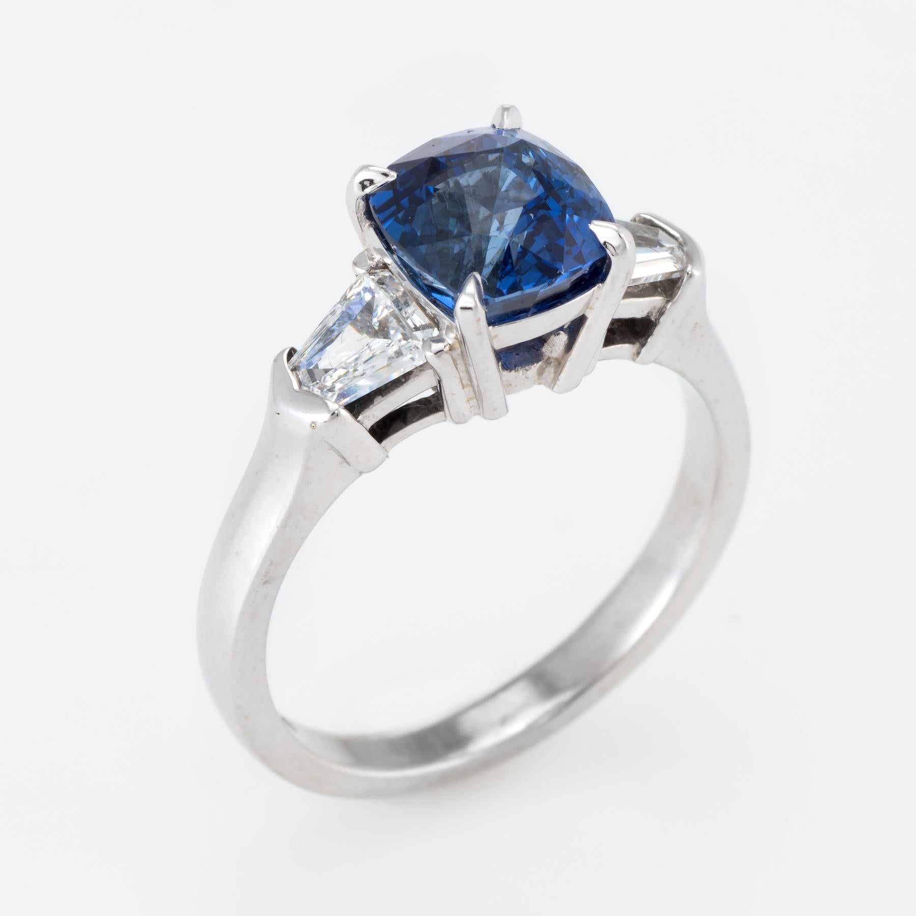 Elegant estate engagement or right hand ring by A. Jaffe, crafted in 18 karat white gold. 

Cushion cut sapphire measures 7.5mm x 7mm (estimated at 3.02 carats), accented with two estimated 0.50 carat trapezoid cut diamonds (total diamond weight is