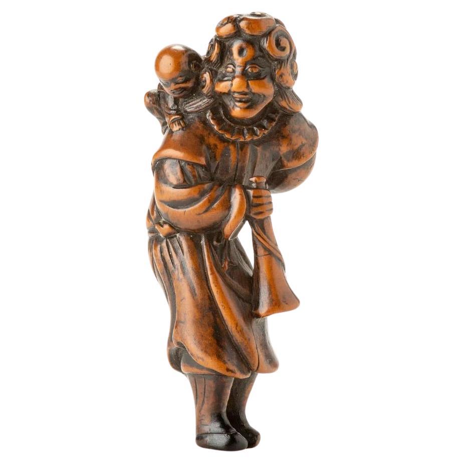 A Japanese boxwood netsuke depicting a Dutchman with a child For Sale