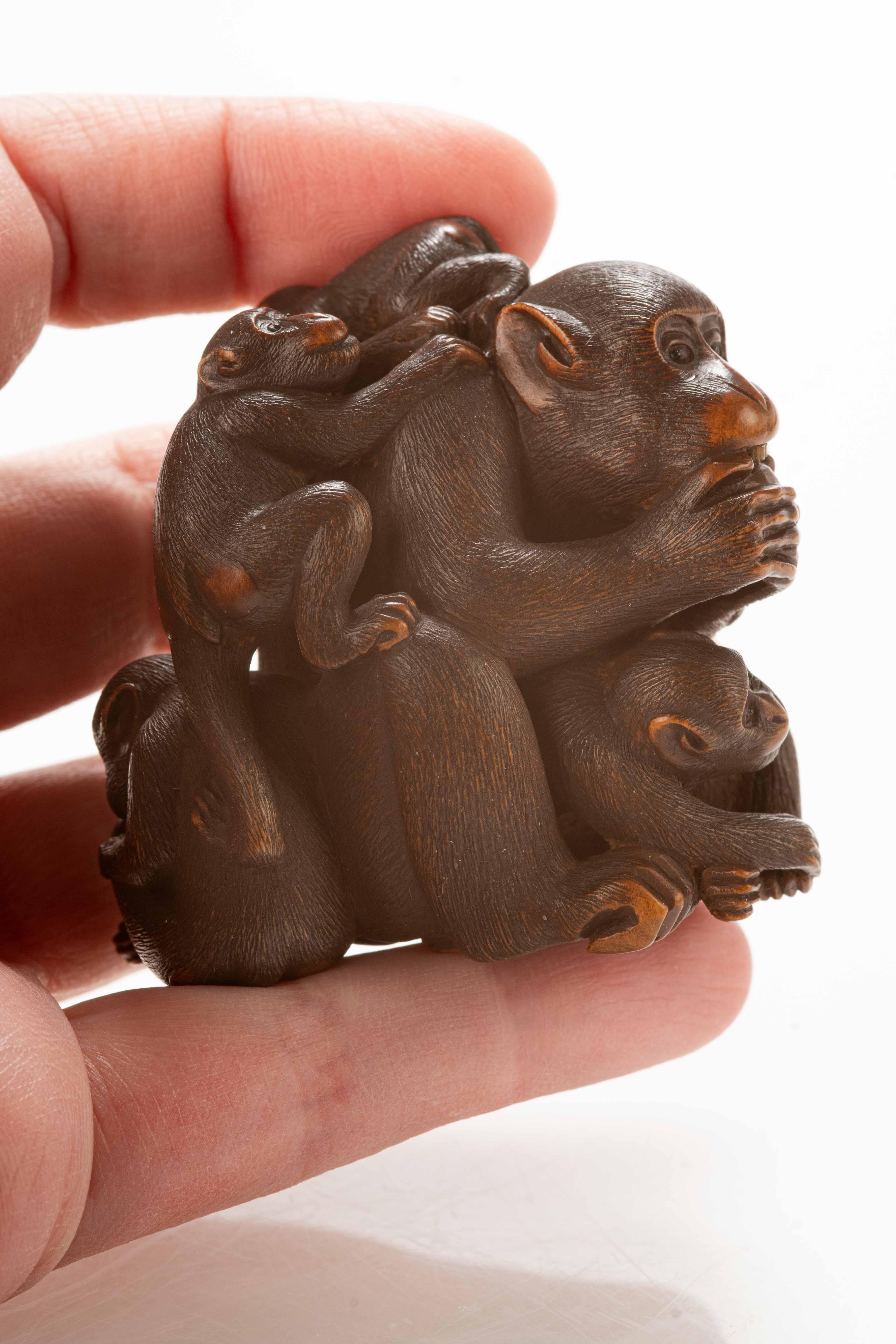 A Japanese boxwood netsuke depicting a group of five monkeys 1