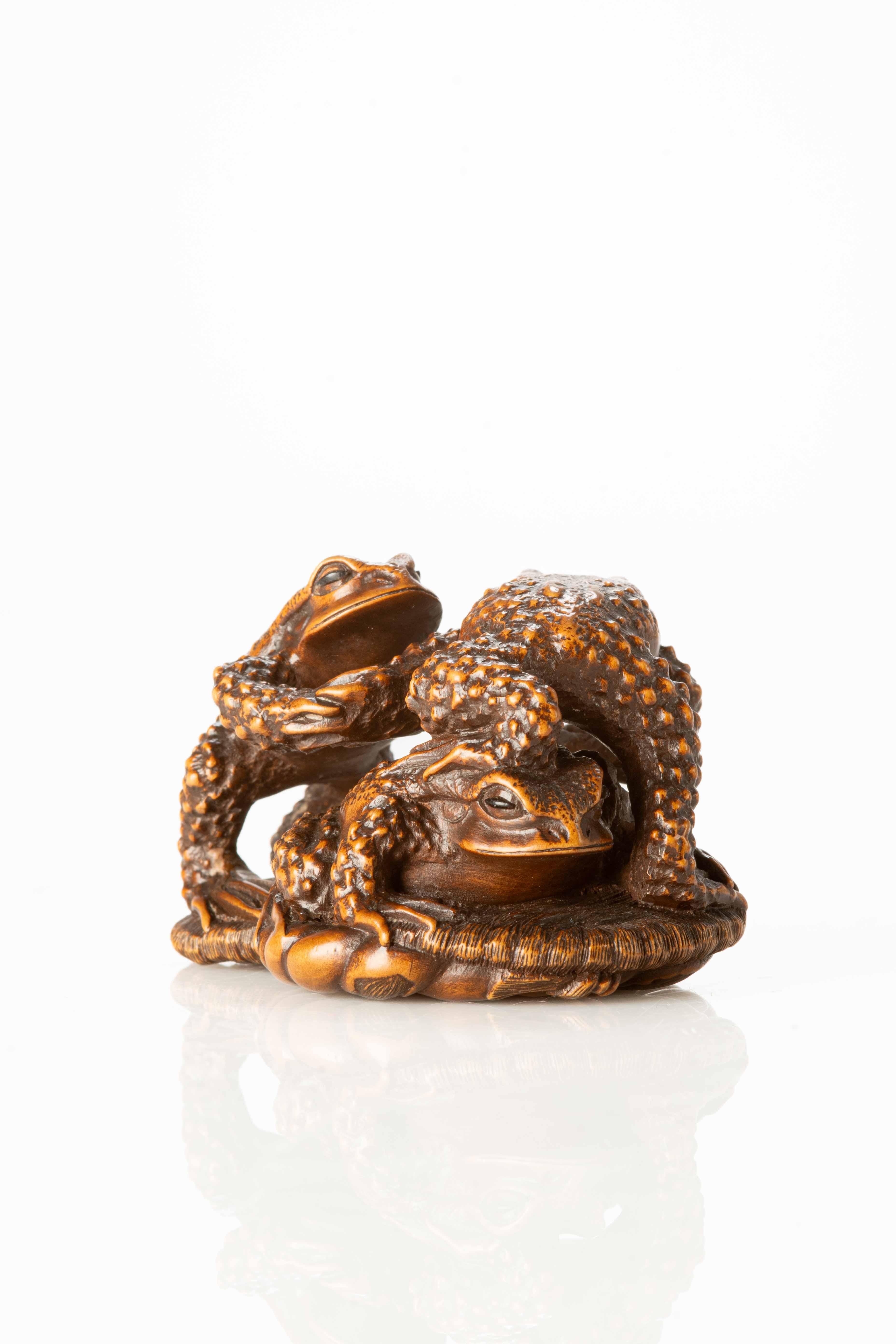 Hand-Crafted A Japanese boxwood netsuke depicting three toads on a sandal