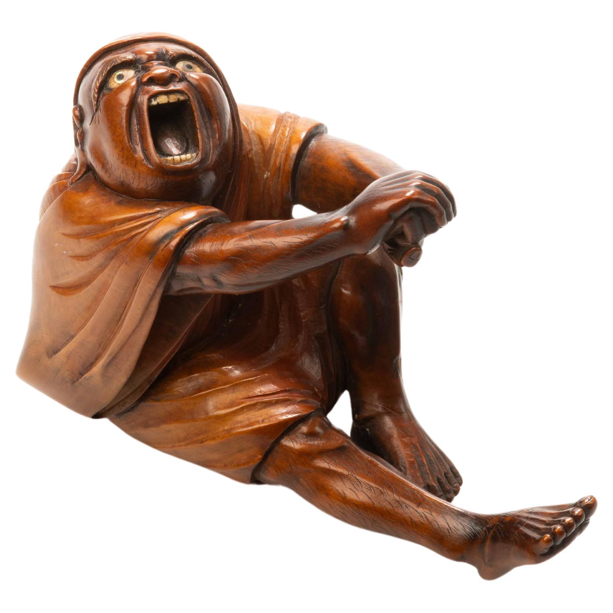 A Japanese boxwood okimono portraying the moment of Daruma's awakening For Sale