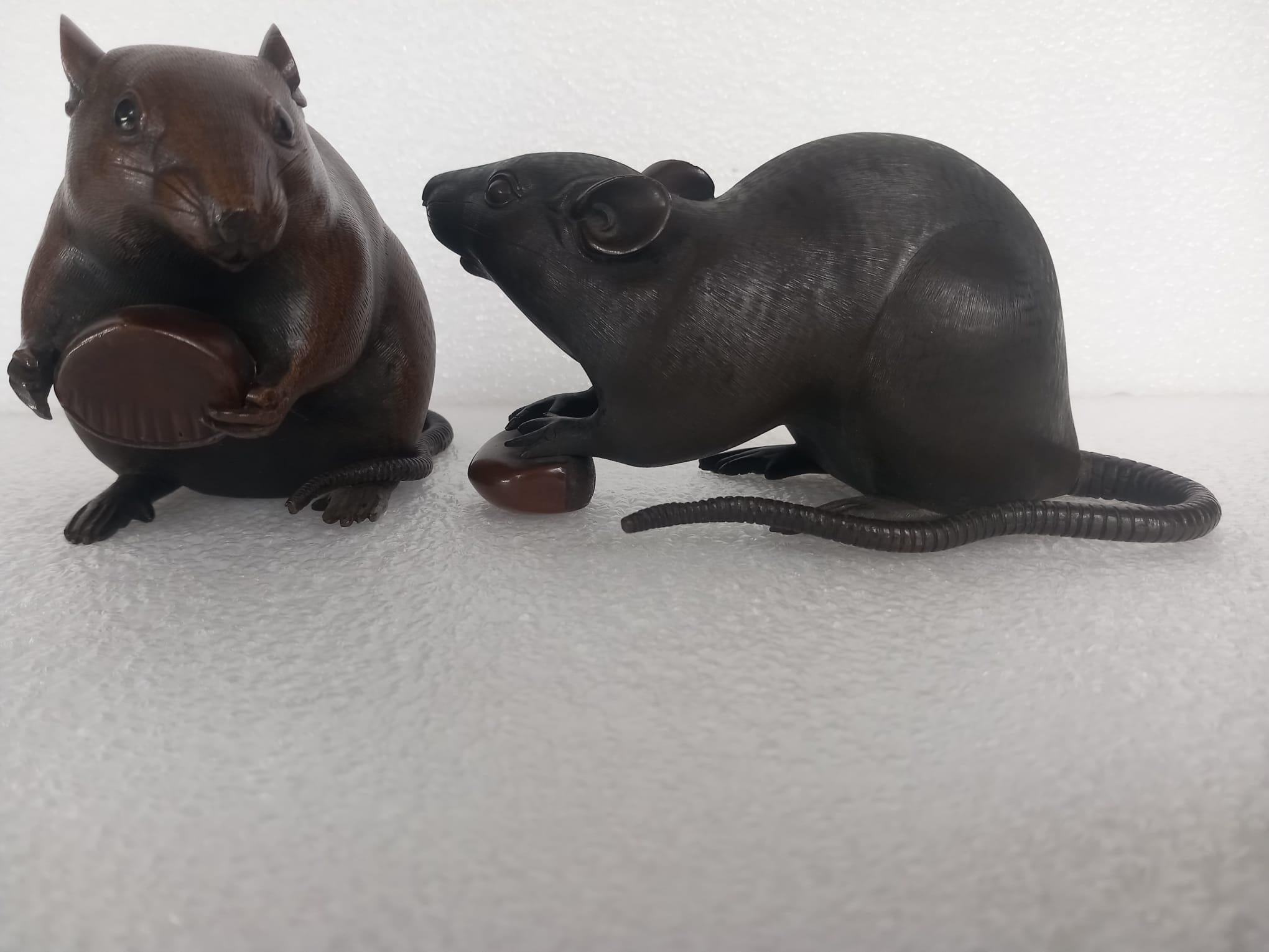 Set contains two: A Japanese bronze of a rat, Meiji Period, signed, approximately 9cm long x 8cm high and another Japanese bronze of a rat, signed, seated on its back legs, brown patina, approximately 17cm long x 9.5cm high 

A Japanese bronze model