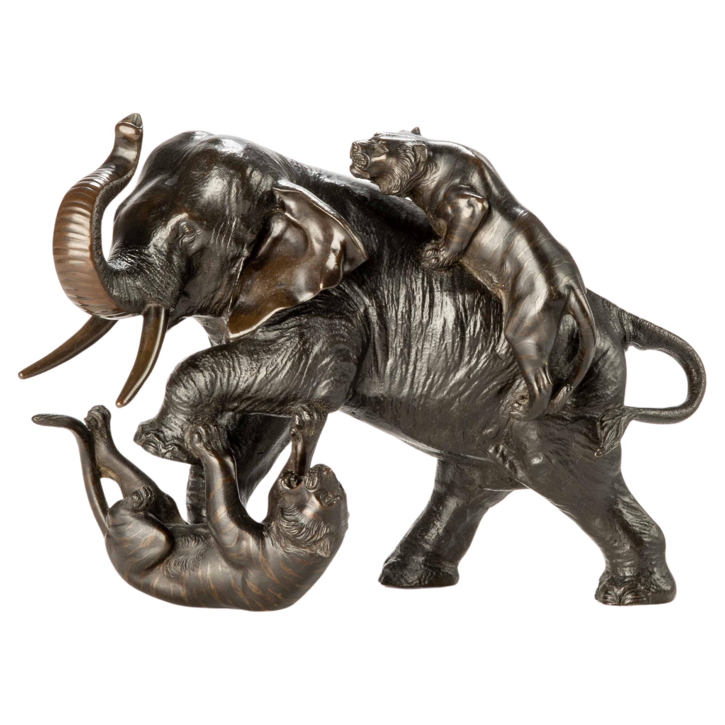 A Japanese bronze okimono depicting an elephant with two tigers