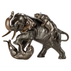A Japanese bronze okimono depicting an elephant with two tigers